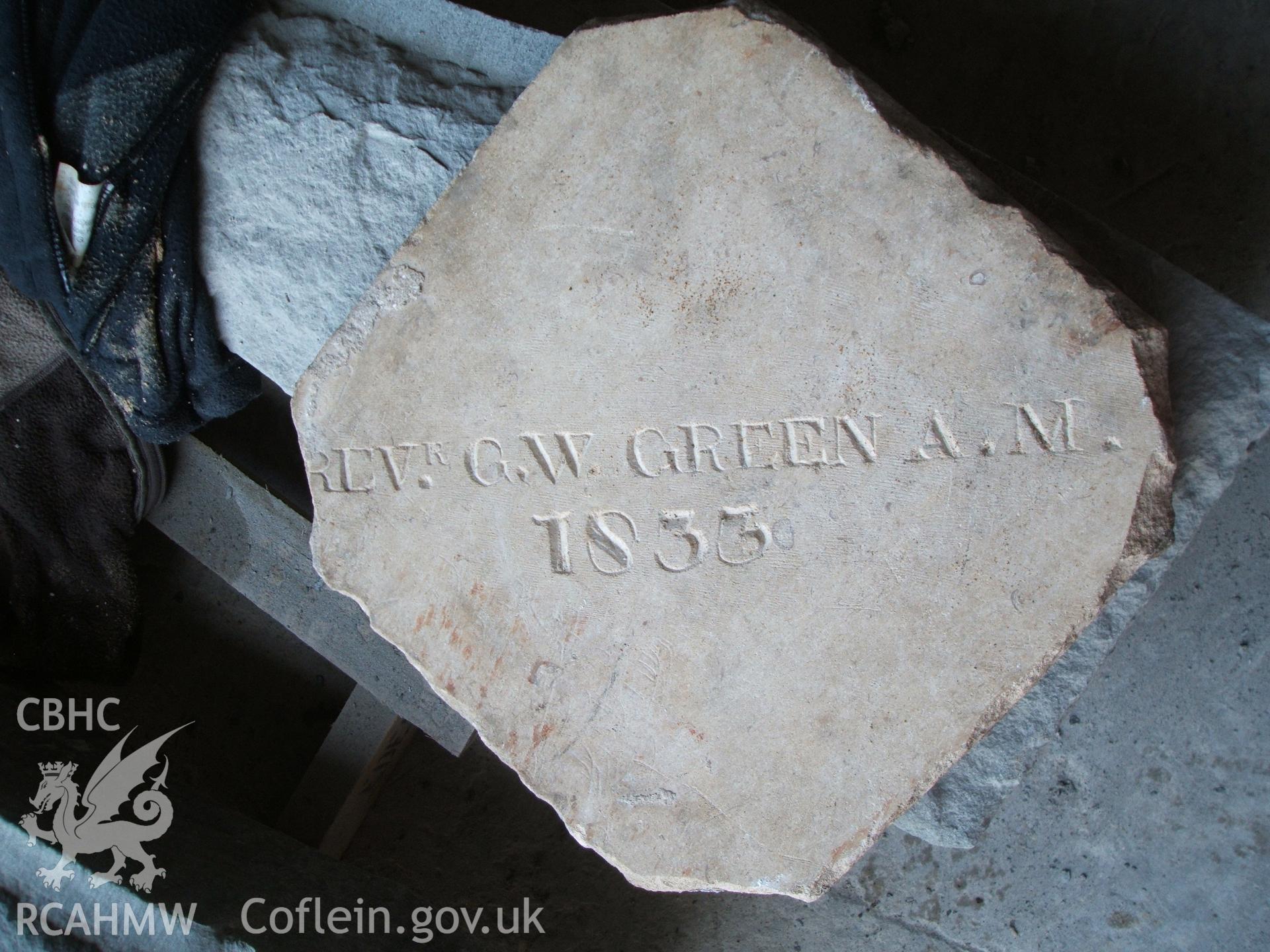 Digital photo showing an inscribed tile found in the hall floor at Court Henry during building work.