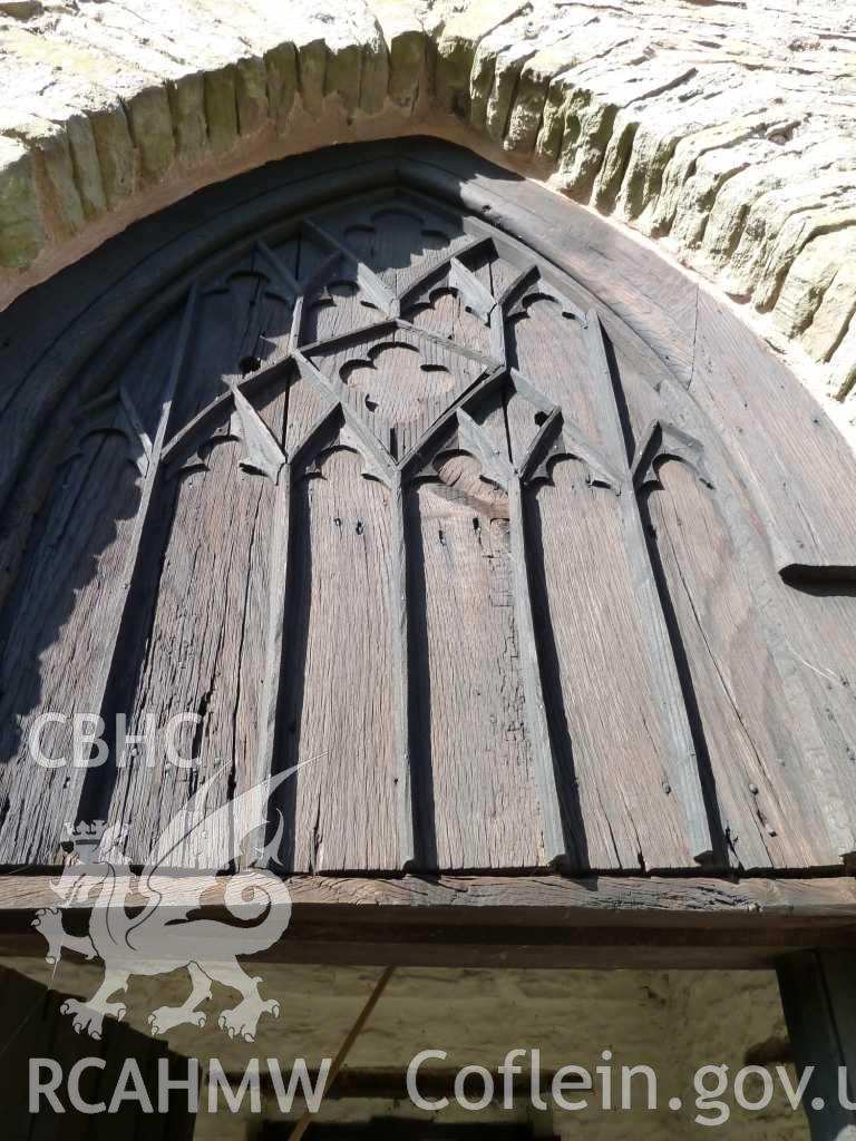 Detail of wooden blind tracery panel above doorway (external).