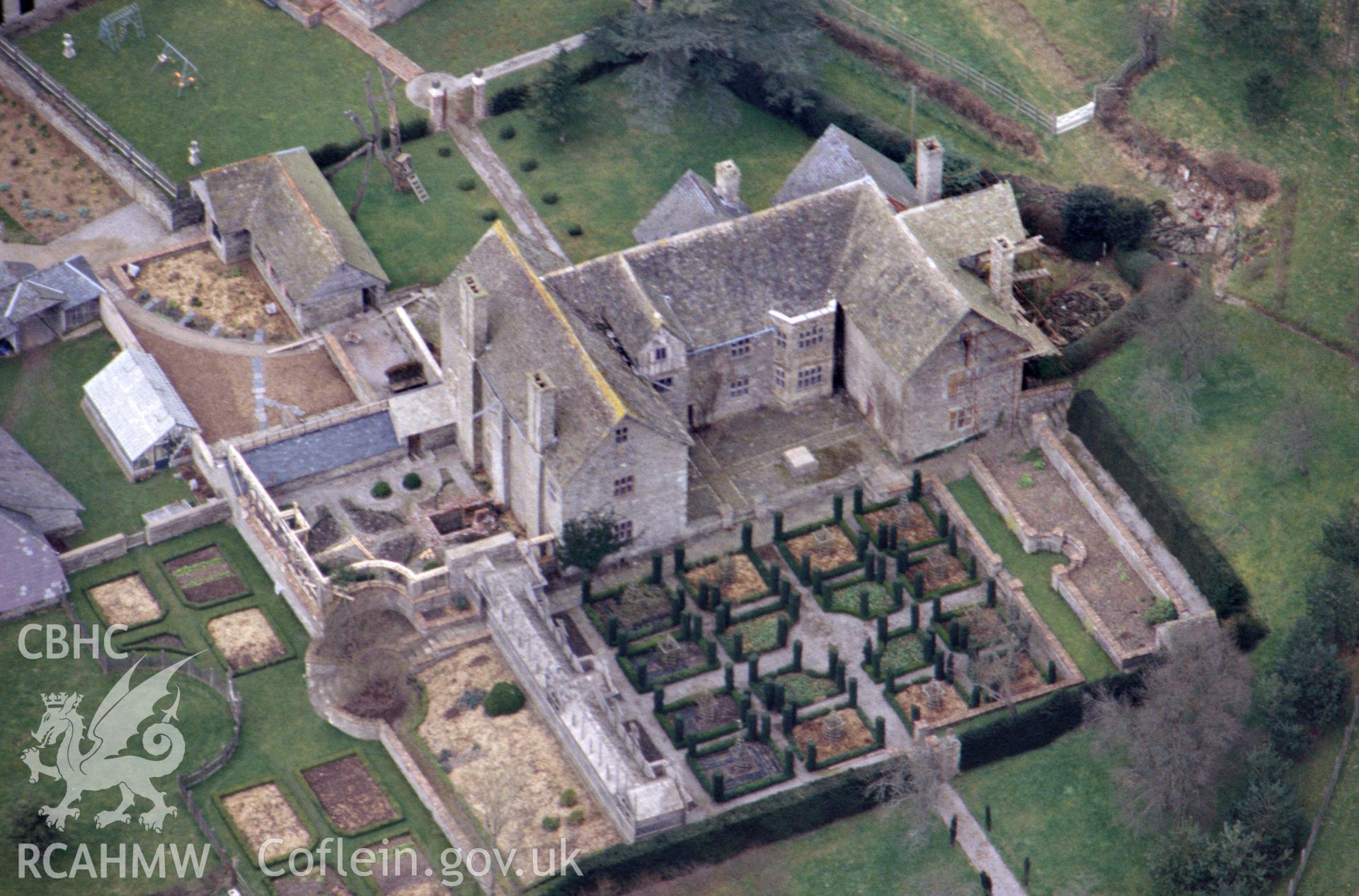 RCAHMW colour oblique aerial photograph of Monaughty House and Gardens. Taken by C R Musson on 21/03/1995