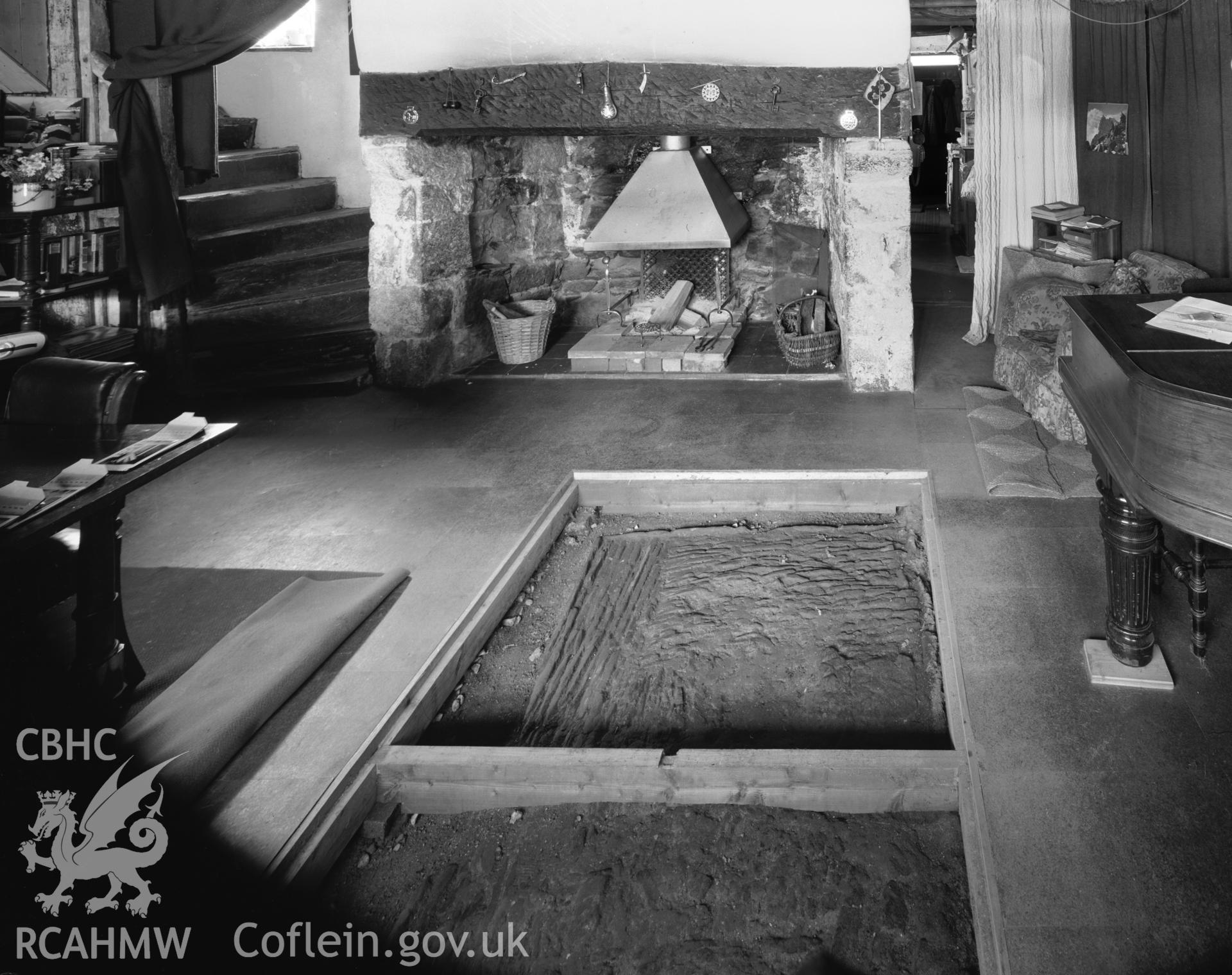 Interior view showing open central hearth and later lateral fireplace.