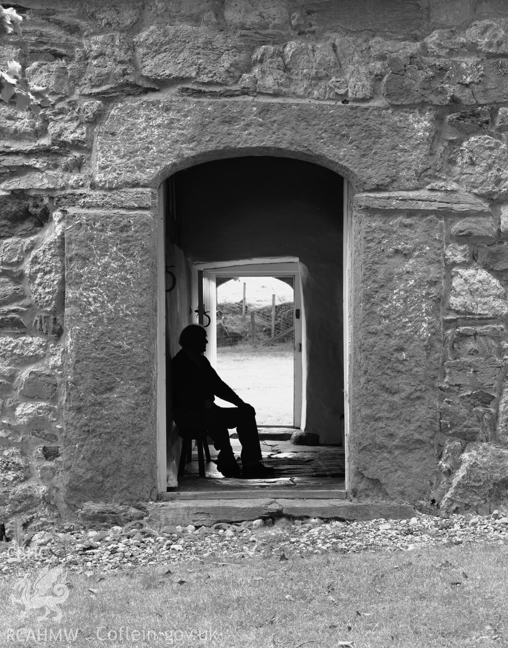 Peter Smith sitting in the doorway of Plas Uchaf.