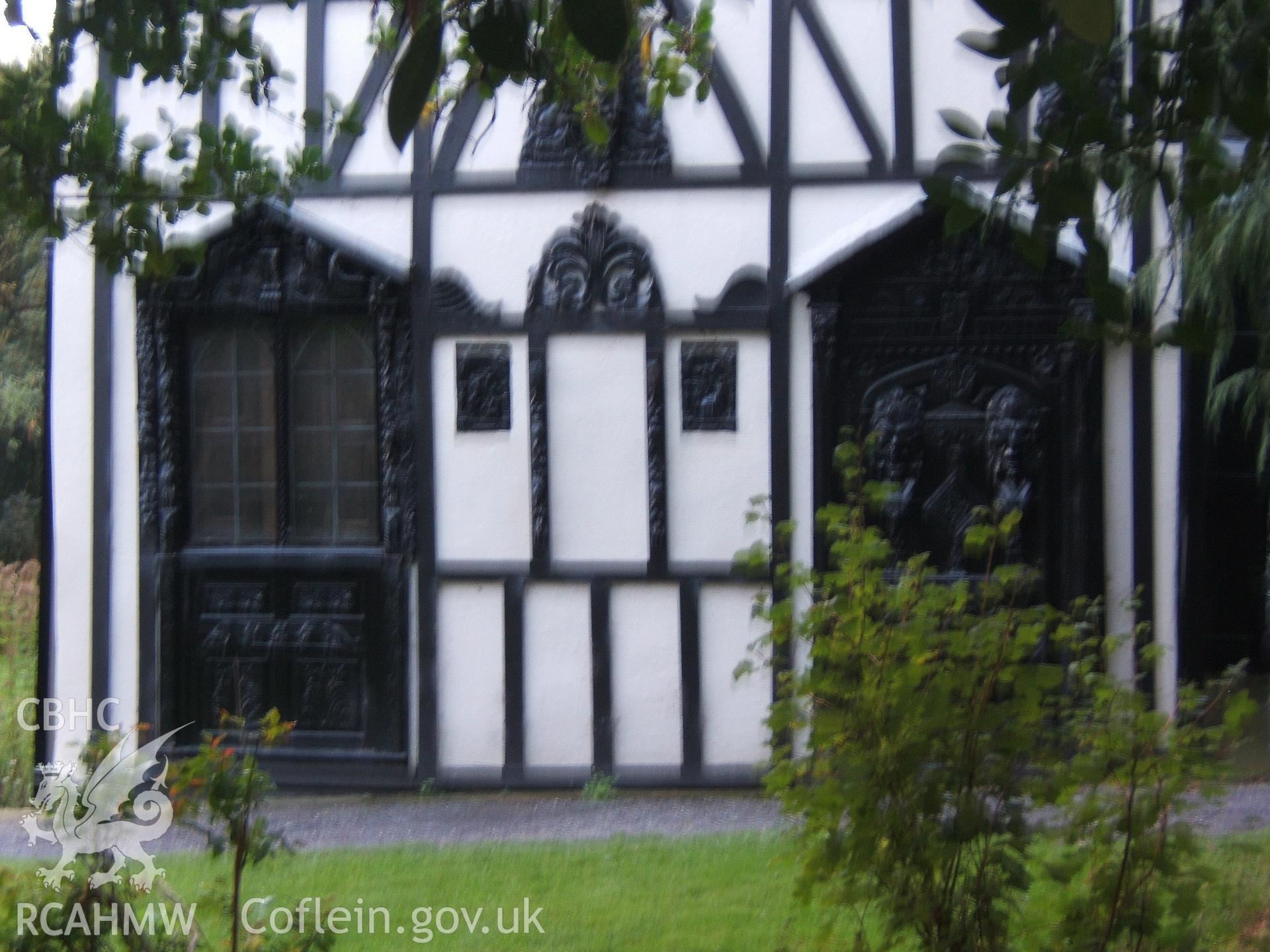 Ornate carving around ground-floor openings on NW gable.