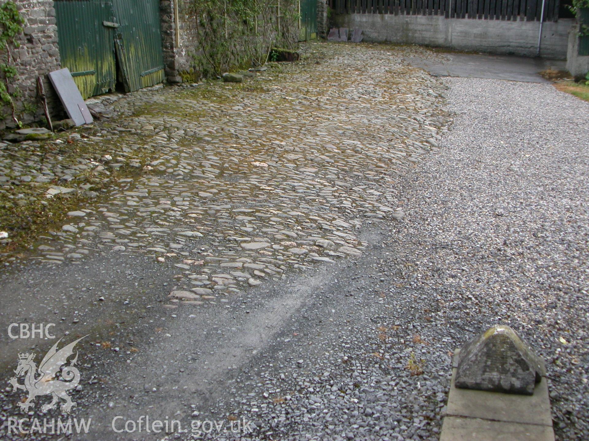 Cobbled area at S front.