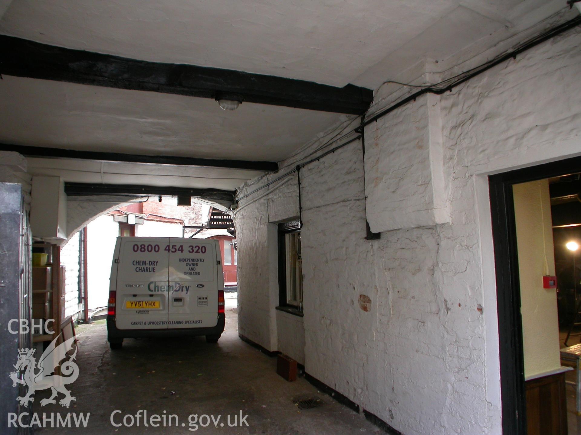 Archway at rear from passage, showing ceiling-beams.