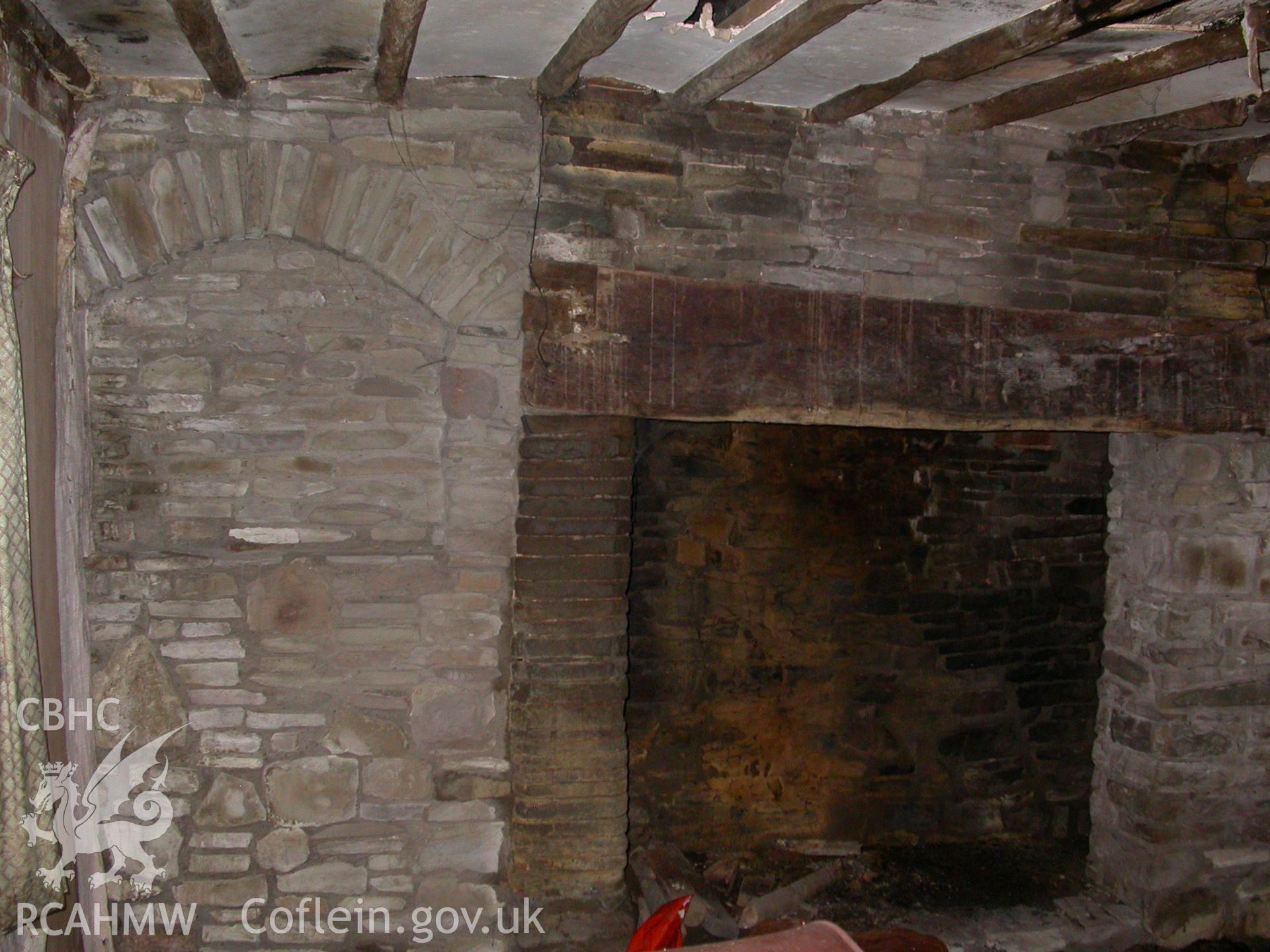 Hall fireplace with blocked former entrance to left.