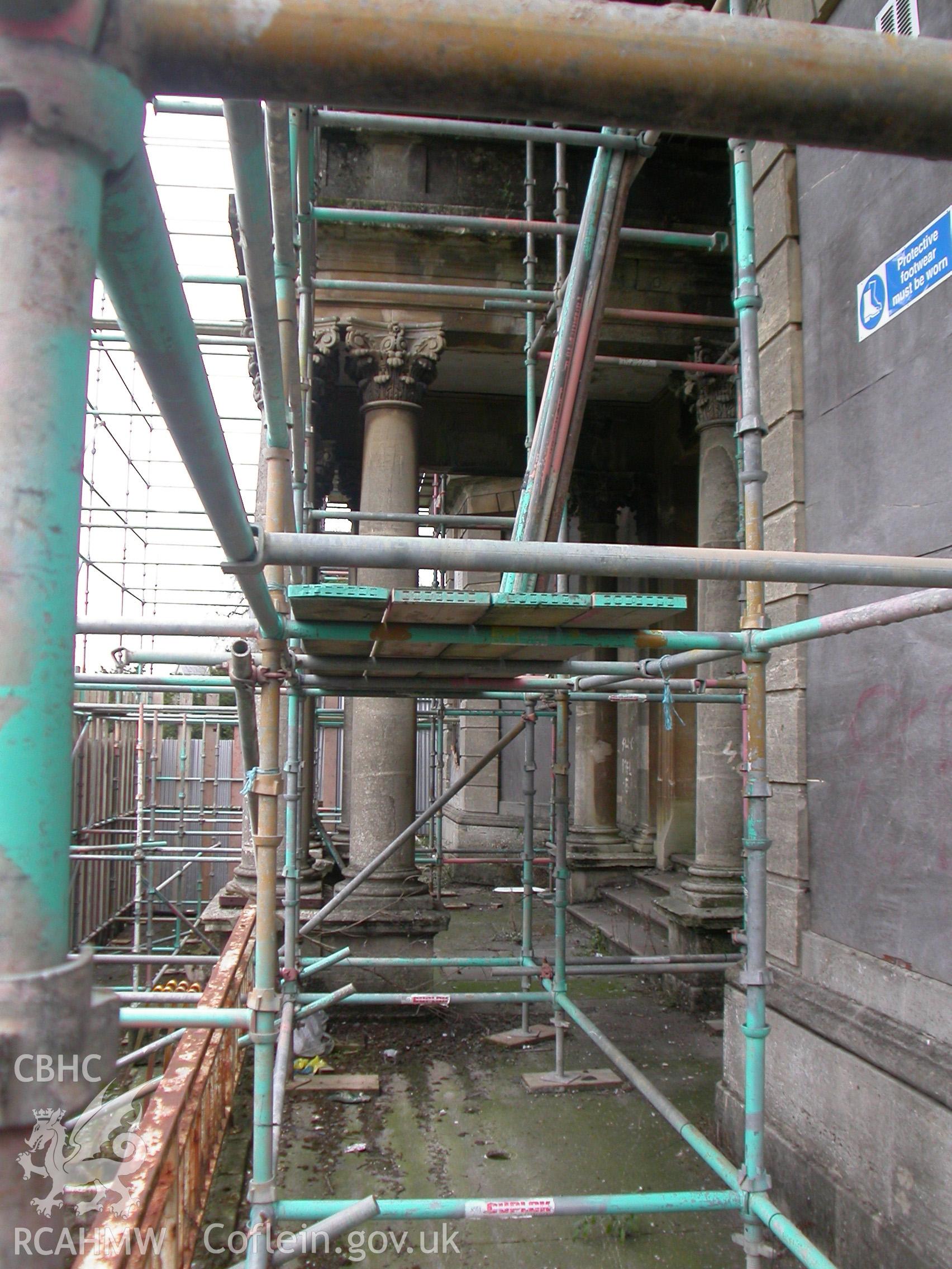 Central entrance portico with flat roof supported by Corinthian columns.