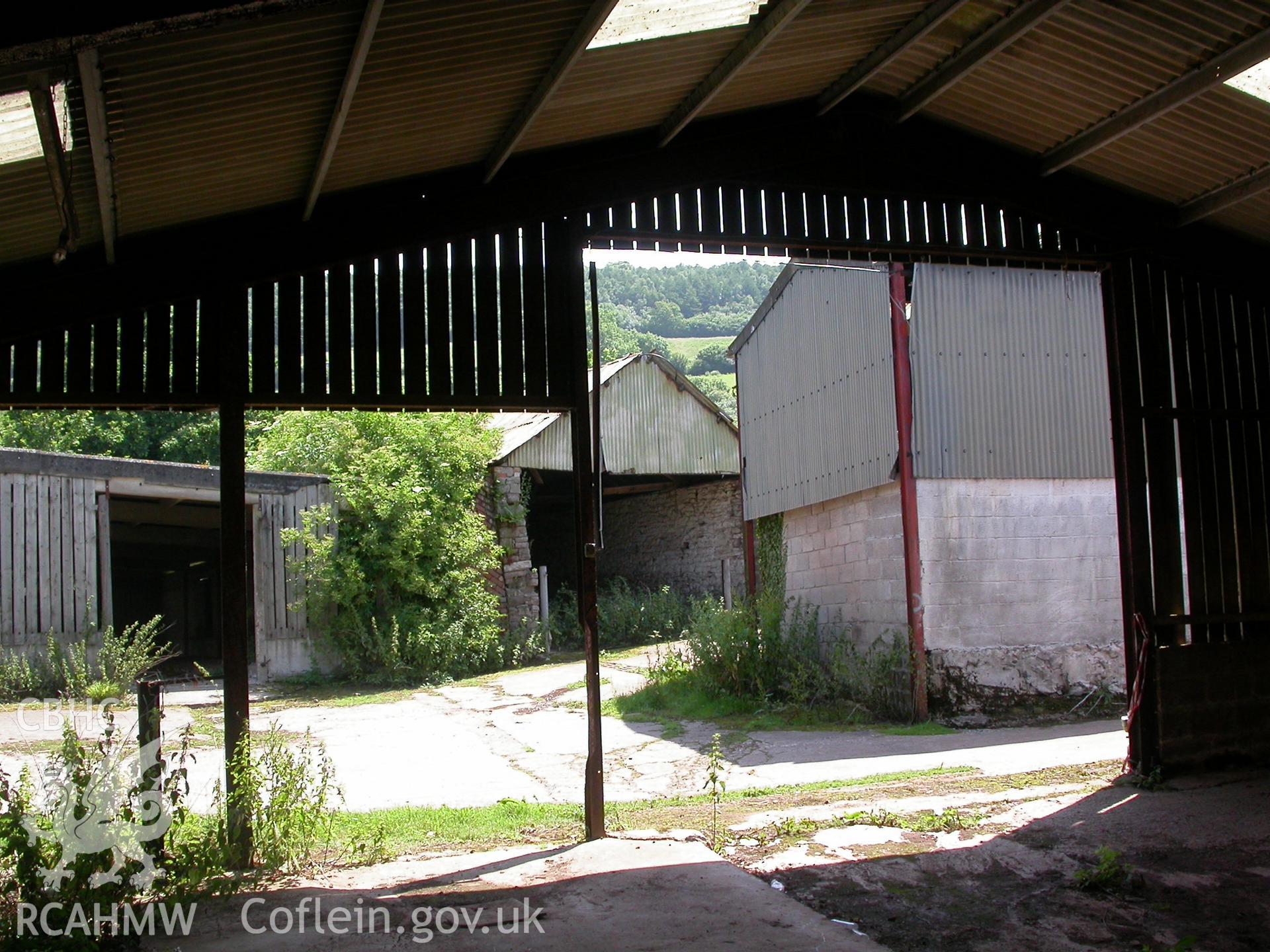 C20th, 4-bay iron girder/corrugated-roof building, open front looking east, to cart/loose-box beyond.