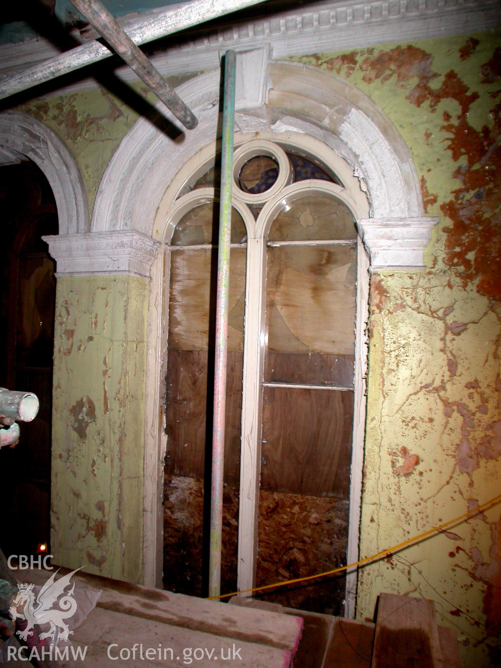 First floor, rounded headed window with simple timber tracery on the north side of the first floor landing.