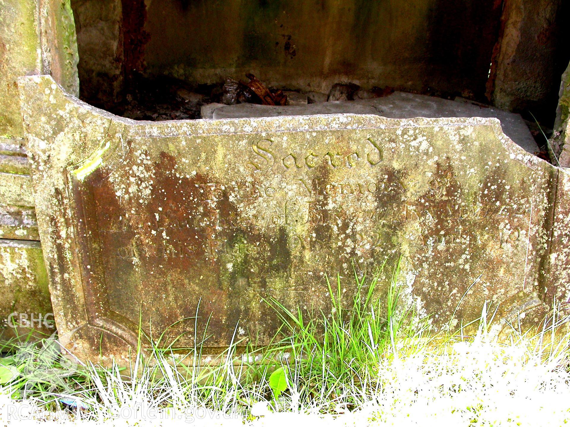 Eroded inscription on the stone table tomb to NE of church.