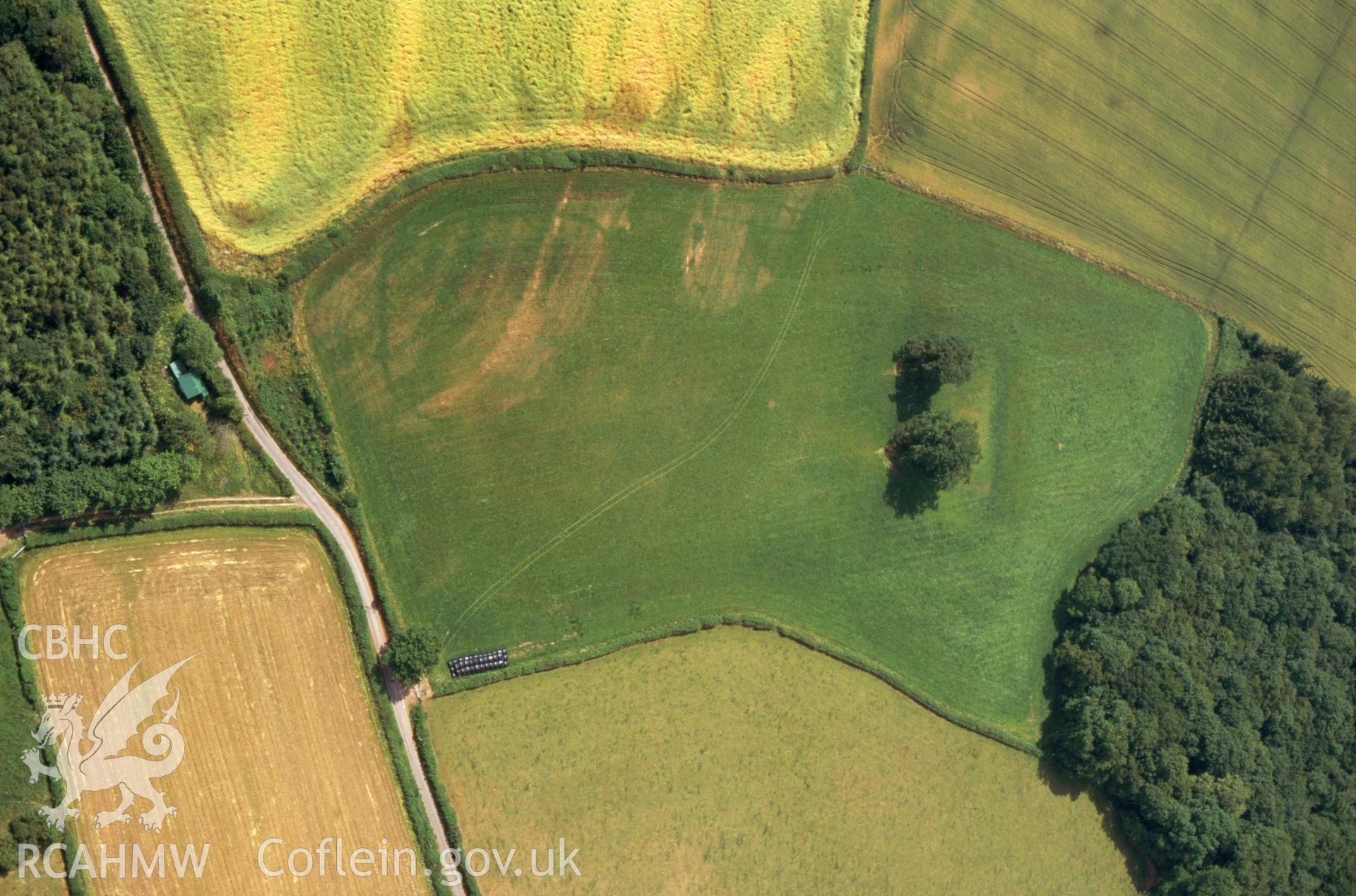 RCAHMW colour slide oblique aerial photograph of Pont-y-bat Moat, Felin-fach, taken by C.R.Musson on the 22/07/1996