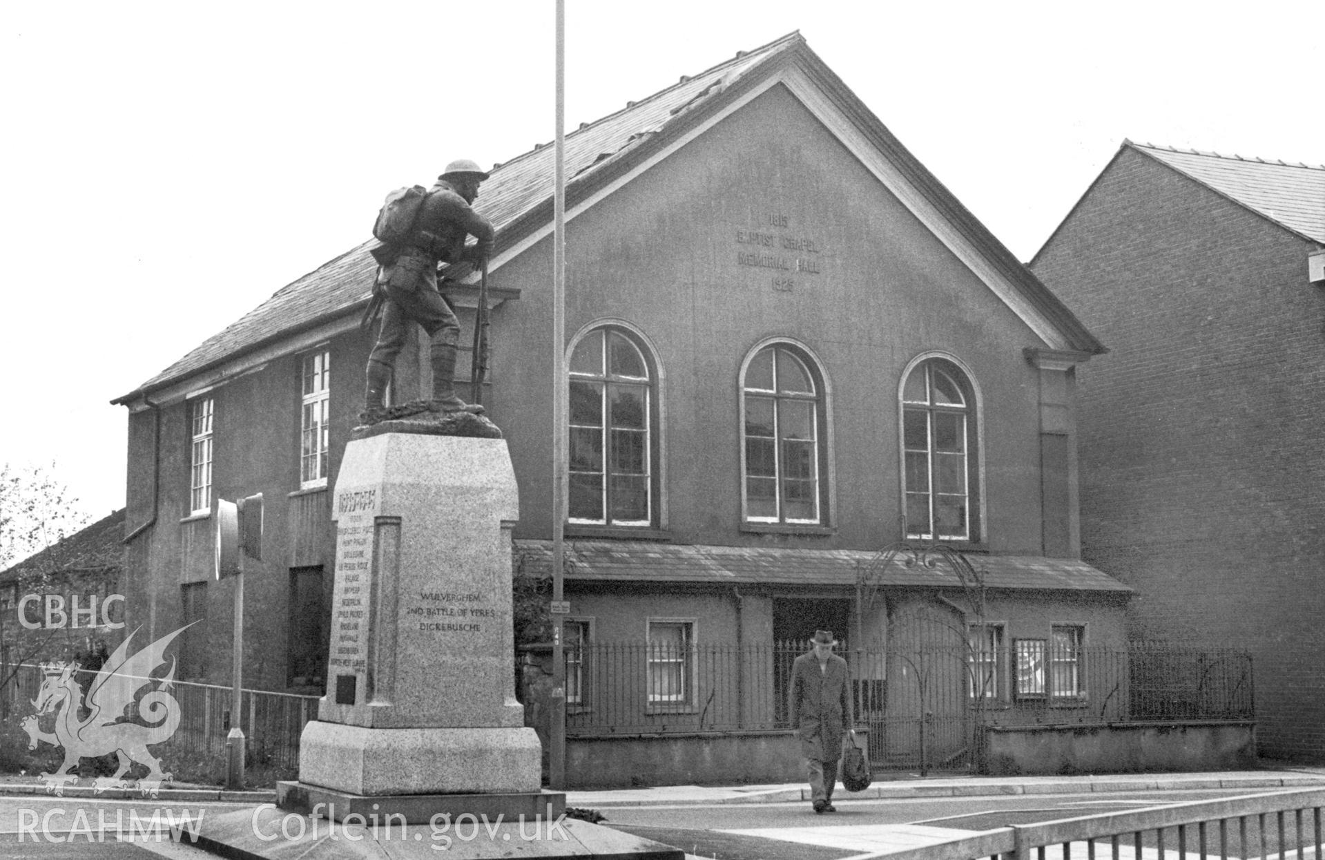 Exterior view showing the gable end of the hall with memorial in foreground.