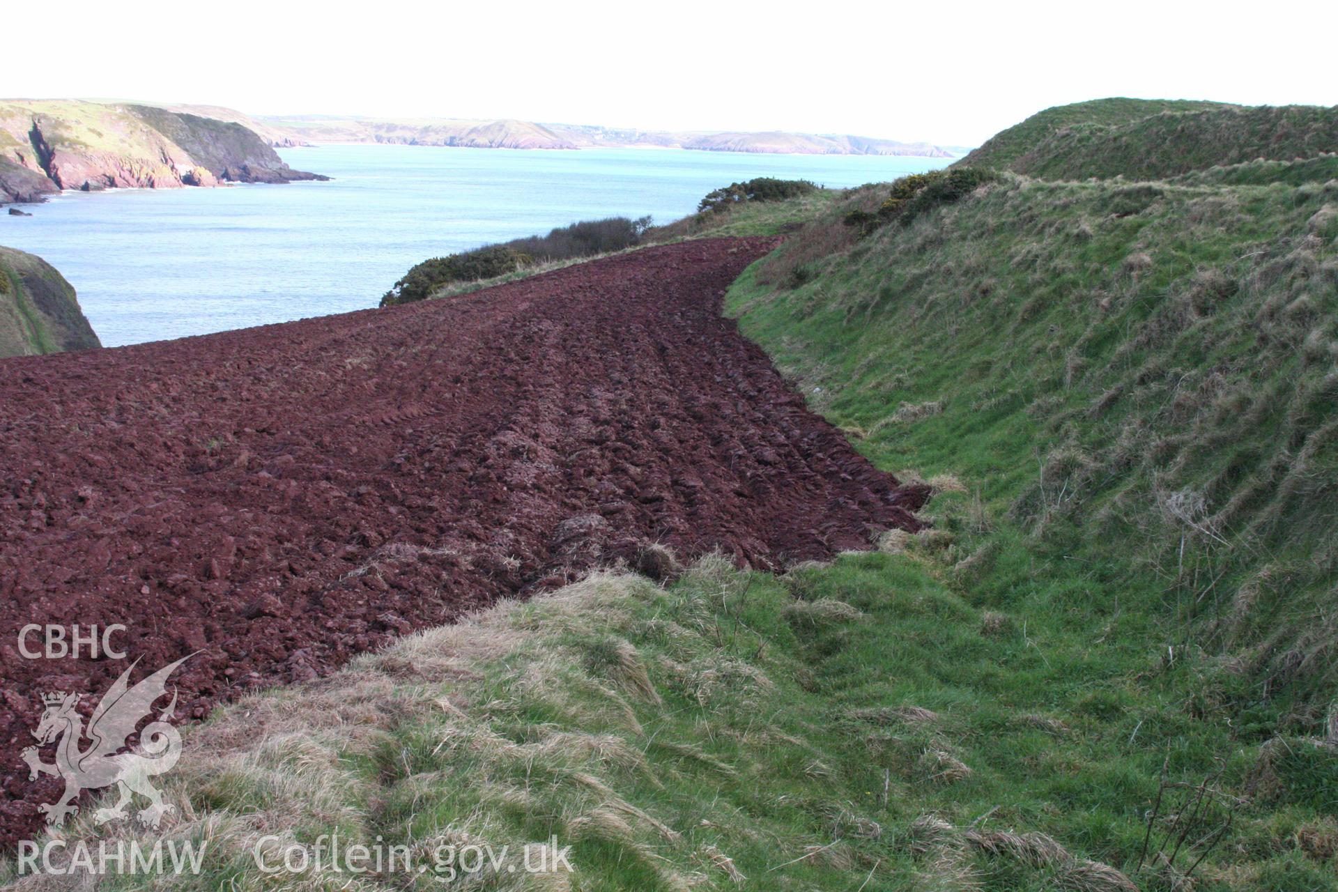 Looking east along the external face of the outer rampart bank of the annexe defences to the main fort entrance.