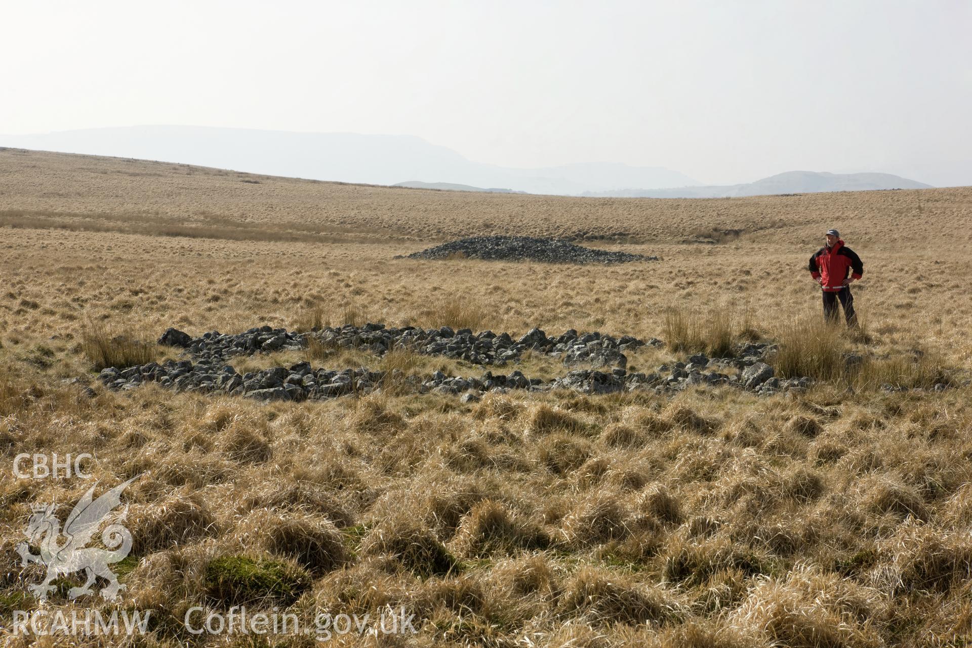 View from east northeast with figure, cairn in background.