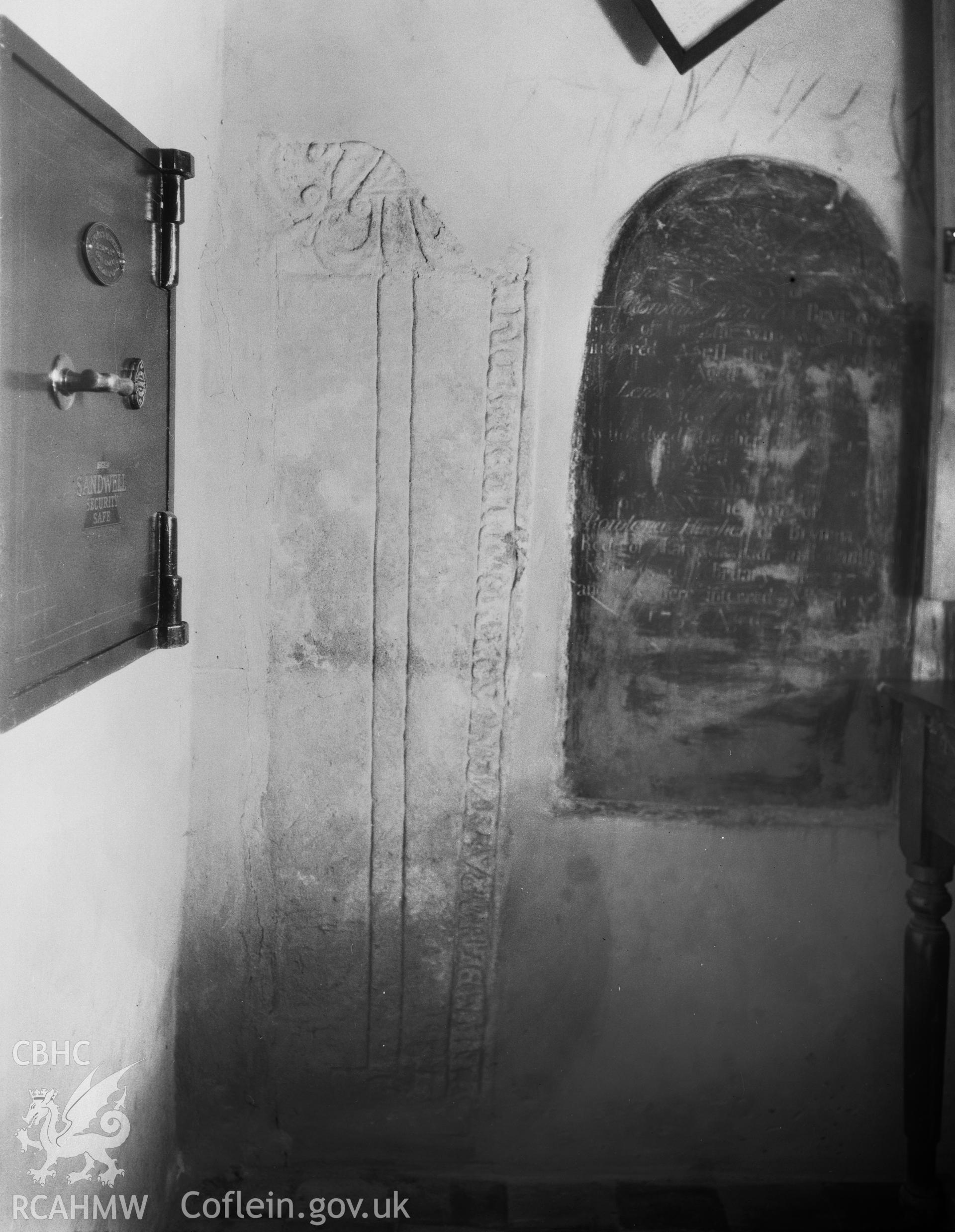 Digitised copy of a black and white negative showing inscribed stone in St Peter's Church, produced by RCAHMW before 1960