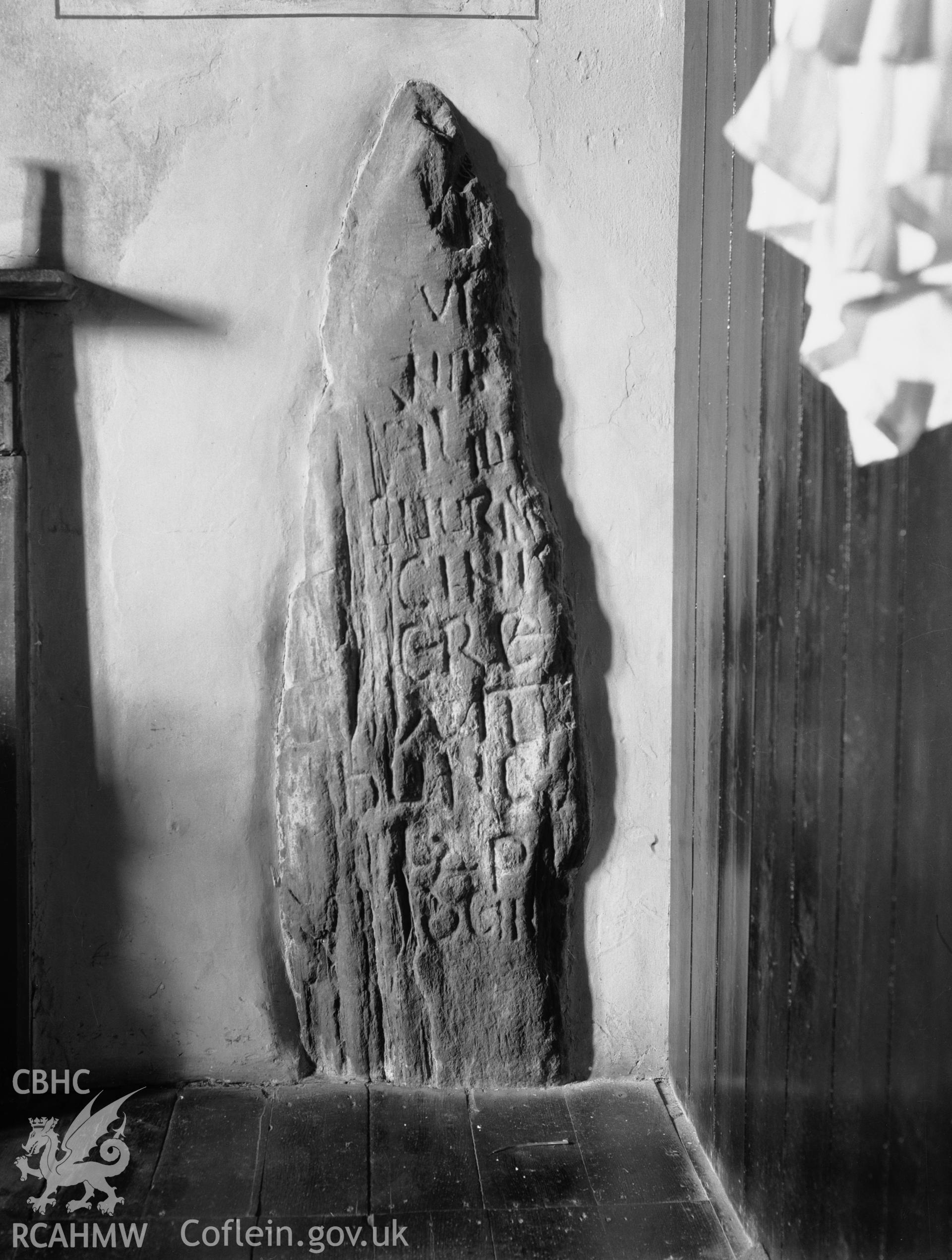 One black and white photograph showing inscribed stone in the vestry, taken by RCAHMW .