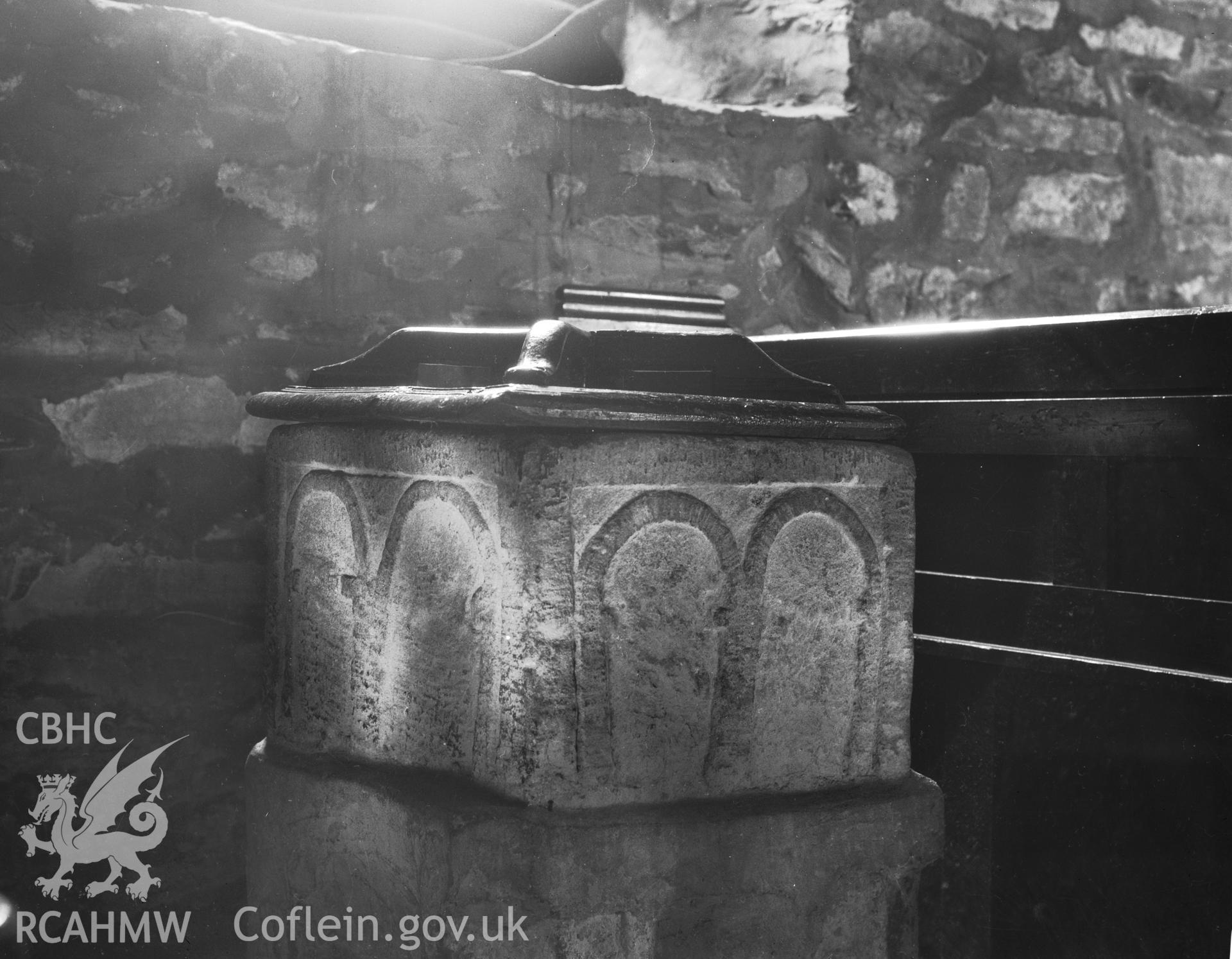 Digitised copy of a black and white negative showing the font in St Mechell's Church, produced by RCAHMW, pre1960.