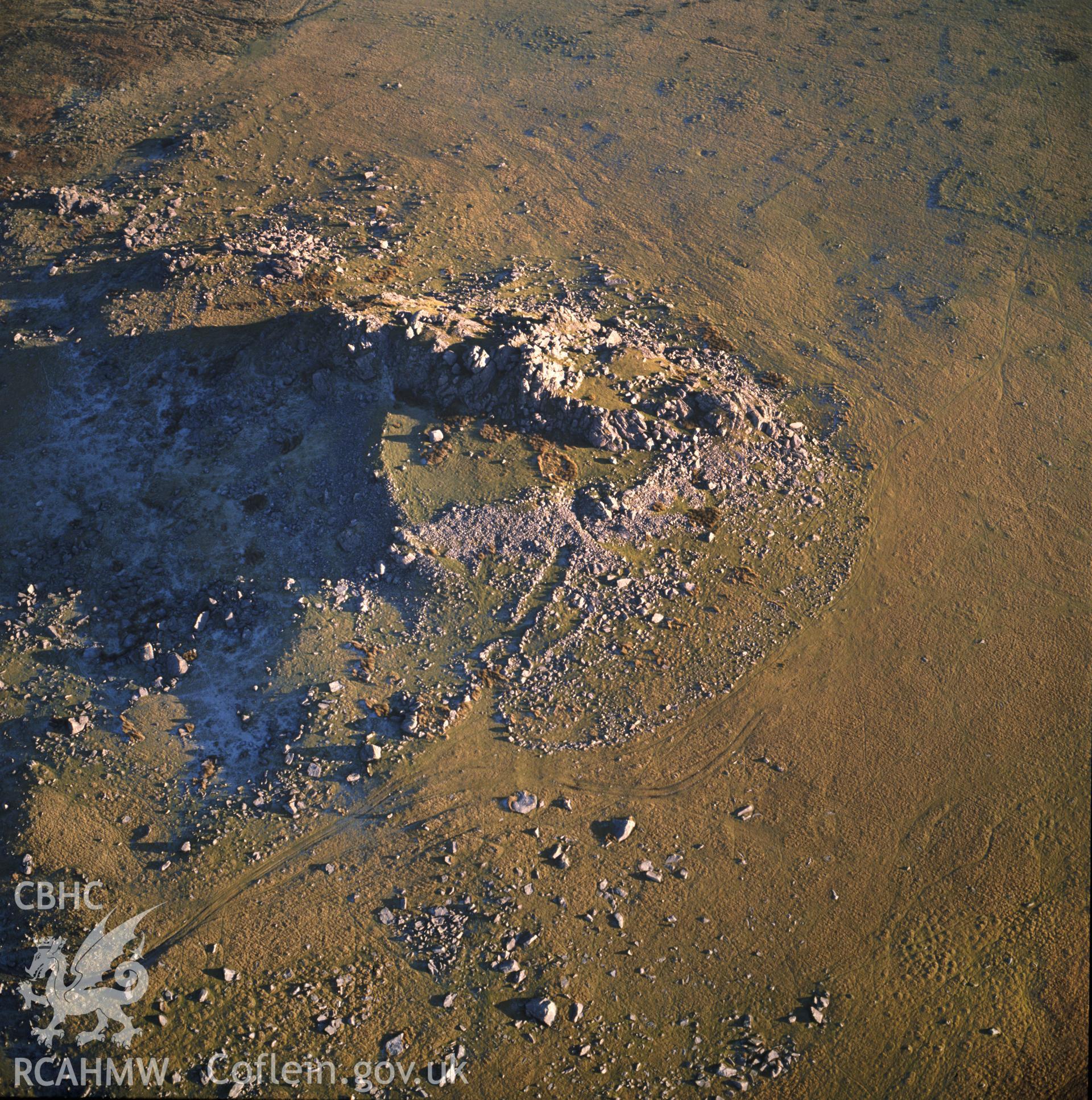 RCAHMW colour oblique aerial photograph of Carn Alw Hillfort, taken by C R Musson, 1990.