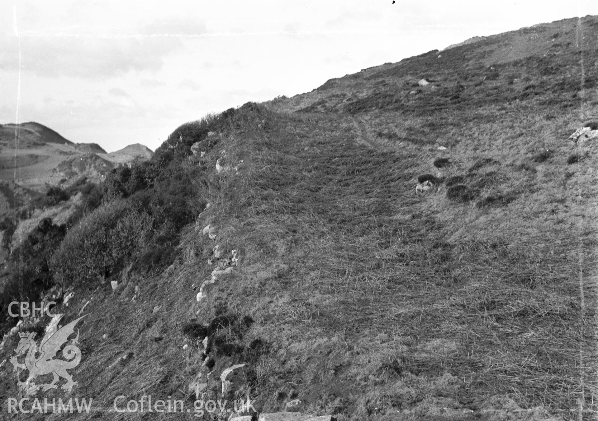 Main wall of Dinas Gynfor looking north-west showing the quarry ditch, taken by RCAHMW c1930.