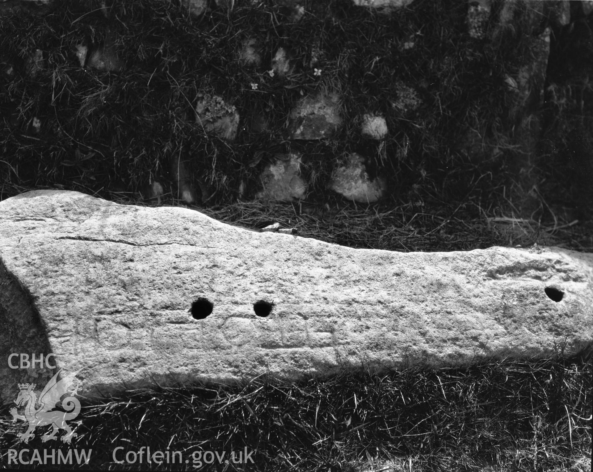 Black and white photograph showing the inscribed stone at Llanol, taken by RCAHMW before 1960.