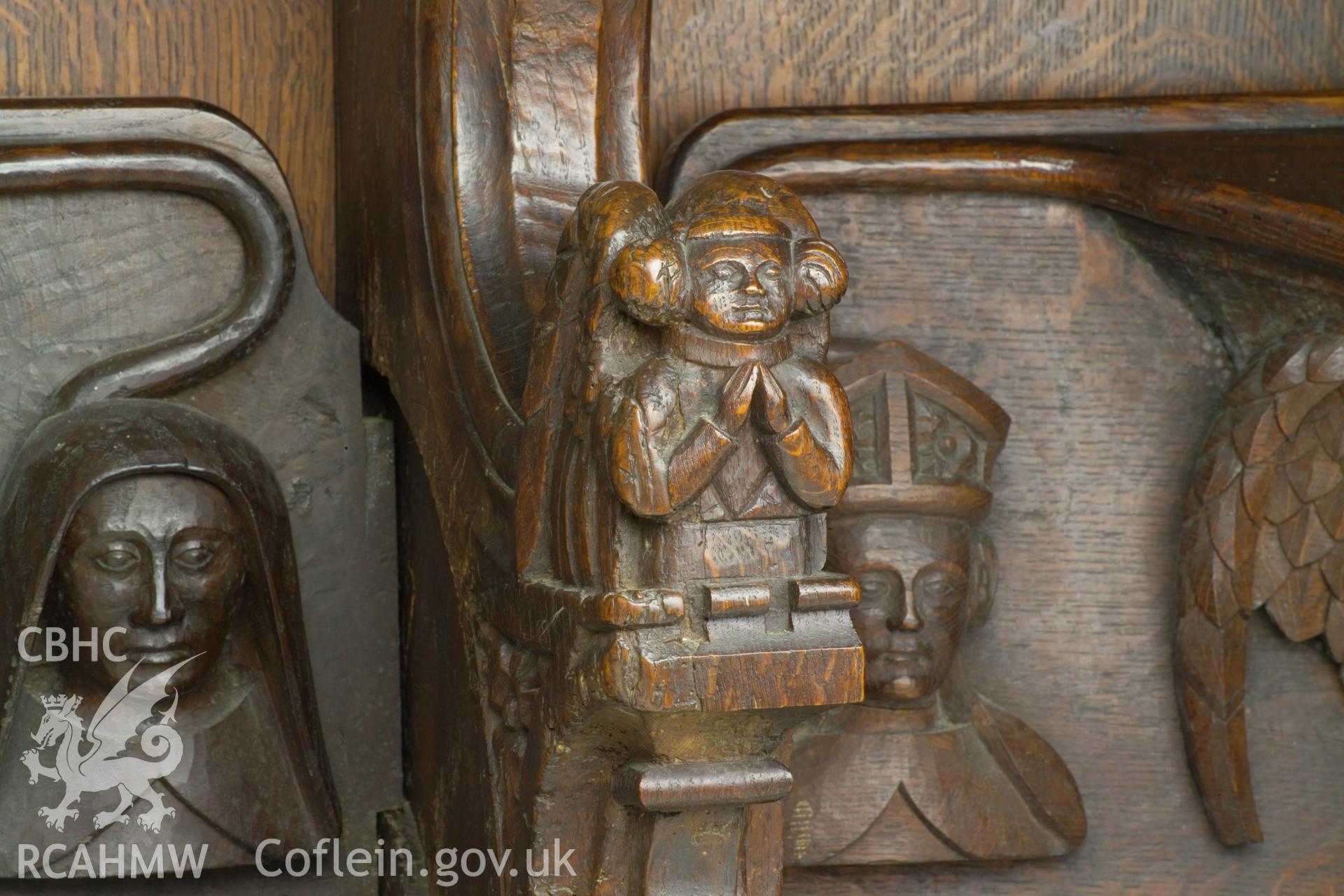 Misericord and dividing arm detail on west screen.