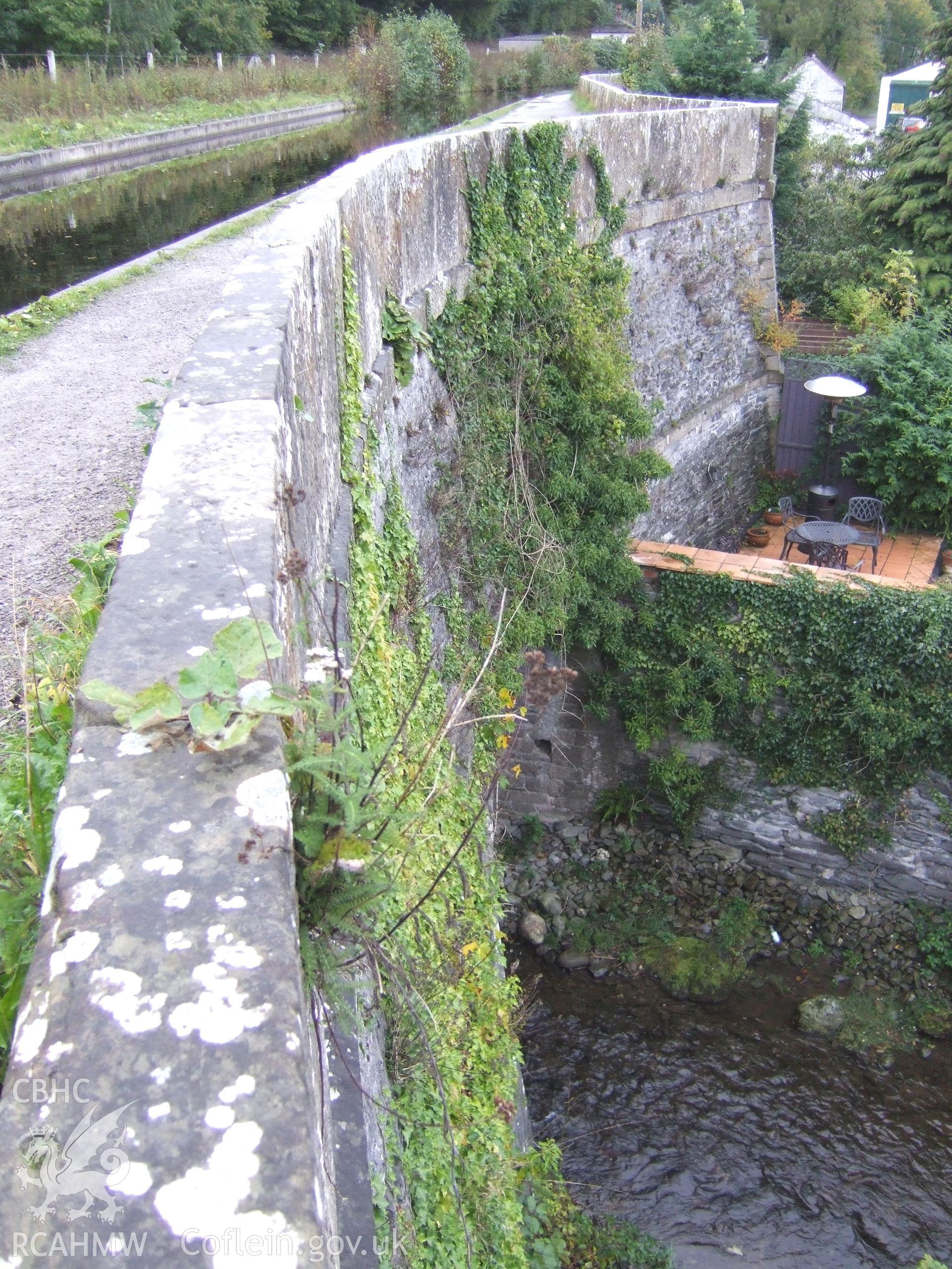 South face of the aqueduct river-arch looking east showing the unusually thin stone parapet of vertical stone square slabs.