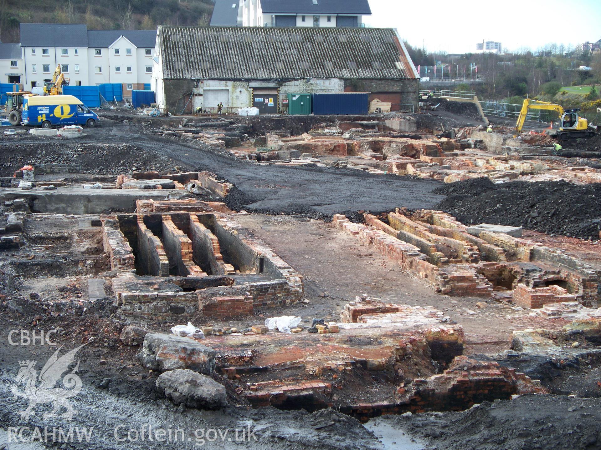 View of central excavations from the NE with two sets of four flues under zinc furnaces & last works building at rear.
