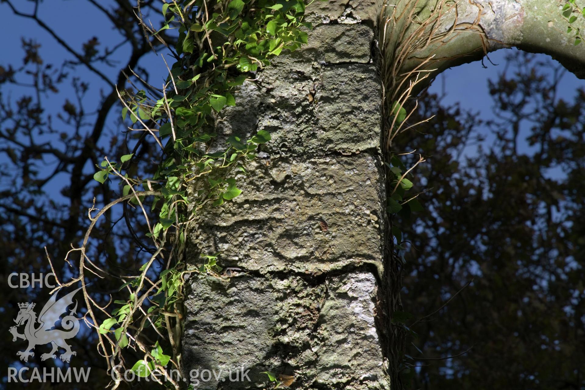 Cross-carved stone lit with artificial light.