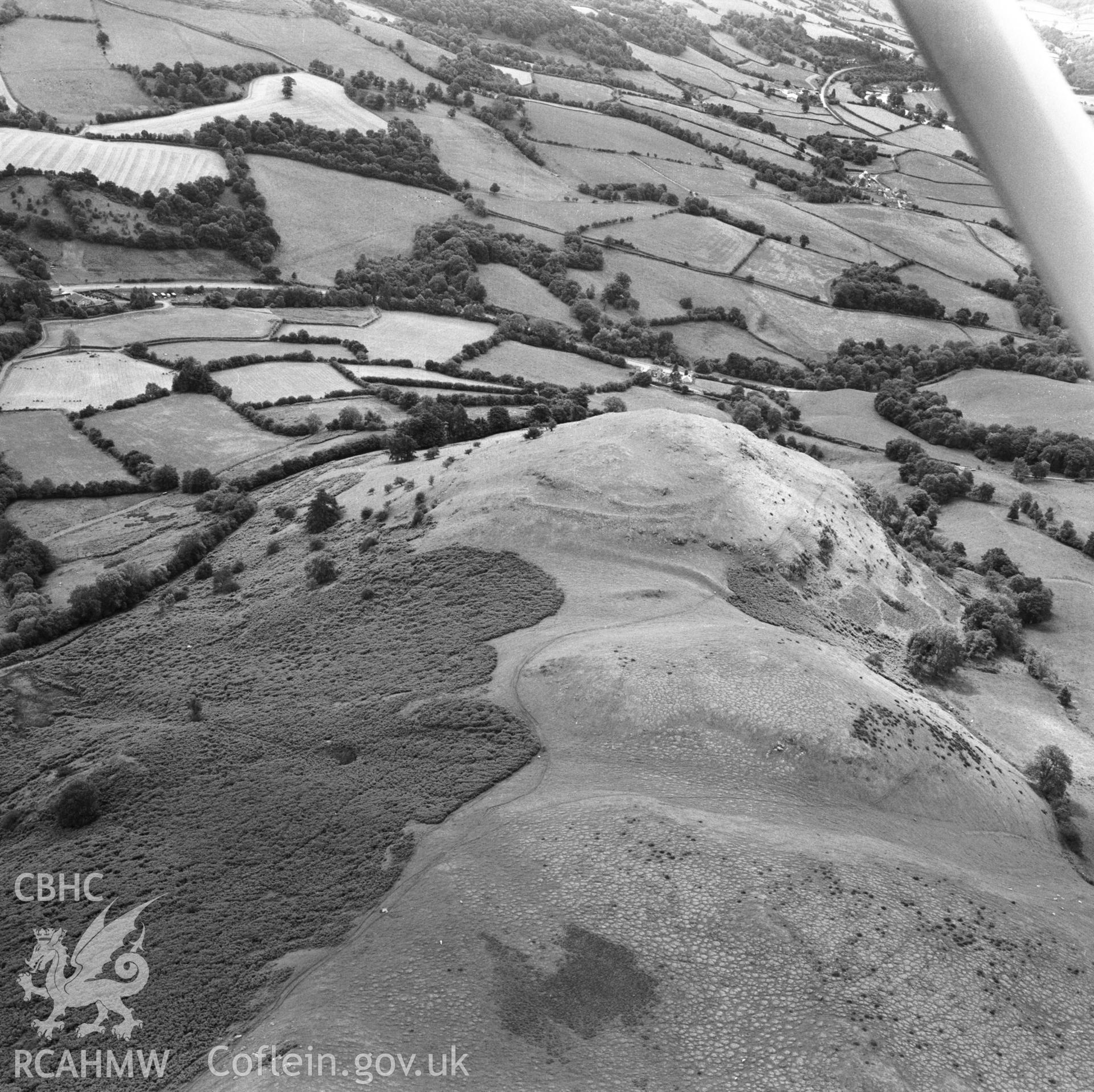 RCAHMW Black and white oblique aerial photograph of Caer Einon, Llanelwedd, taken by CR Musson on 09/07/88