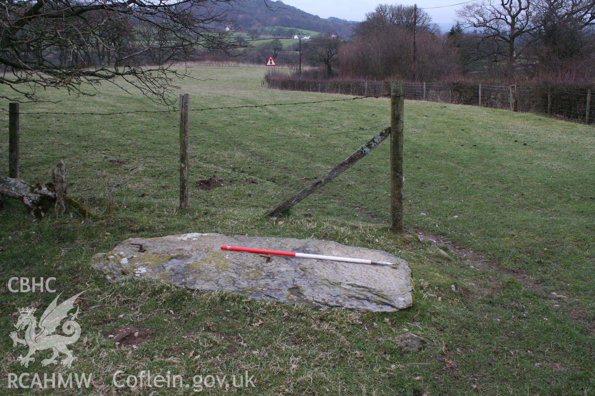 View of former gatepost slab at field entrance, with possible engravings, 1m scale