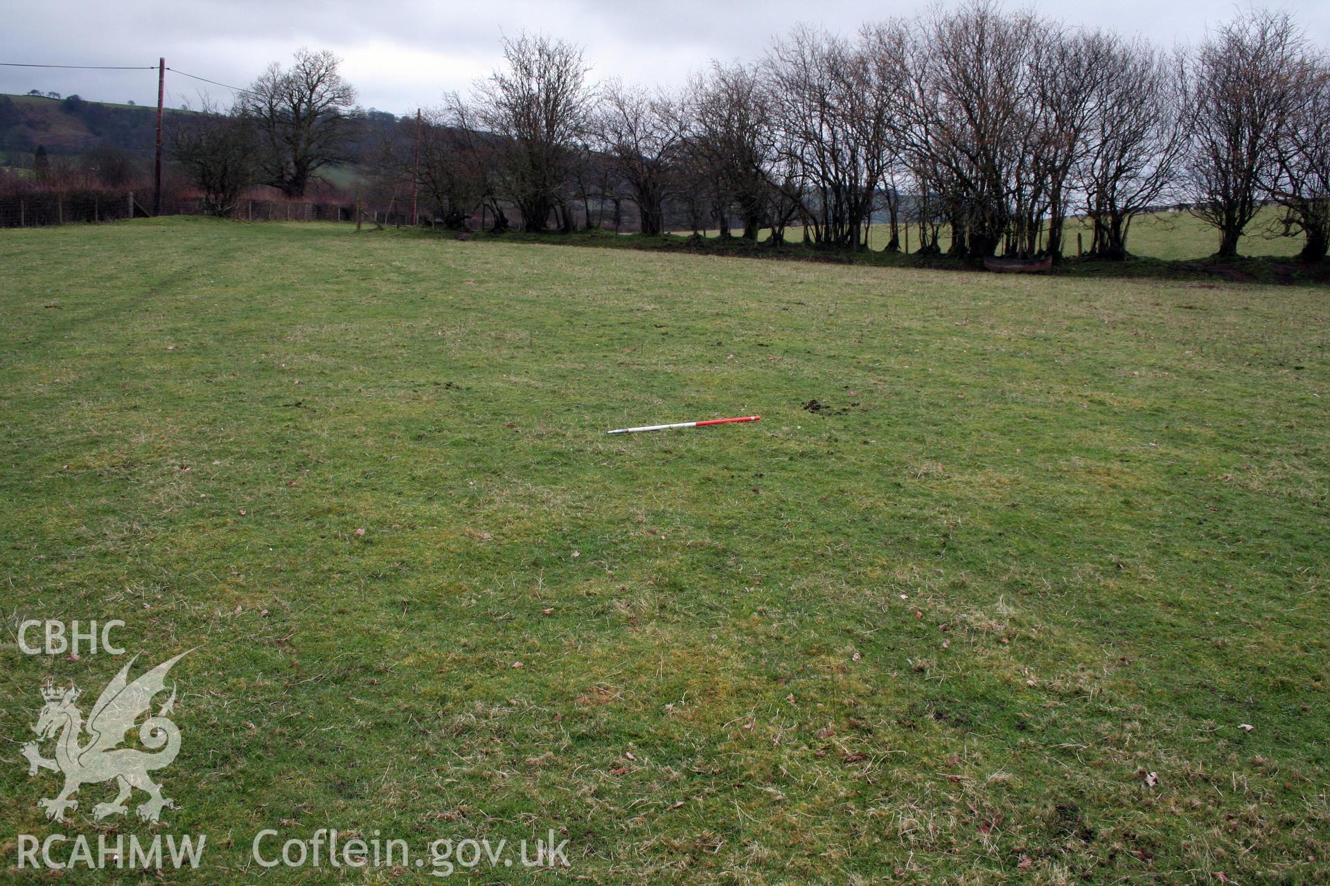 View of plough-levelled barrows (site of) from north-east, showing possible slight earthwork, 1m scale