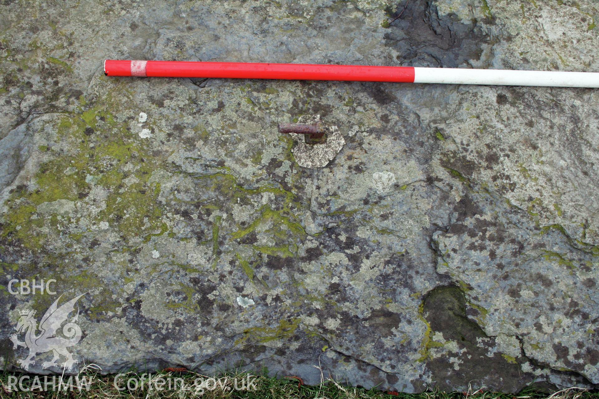 View of former gatepost slab at field entrance, with possible engravings, 1m scale