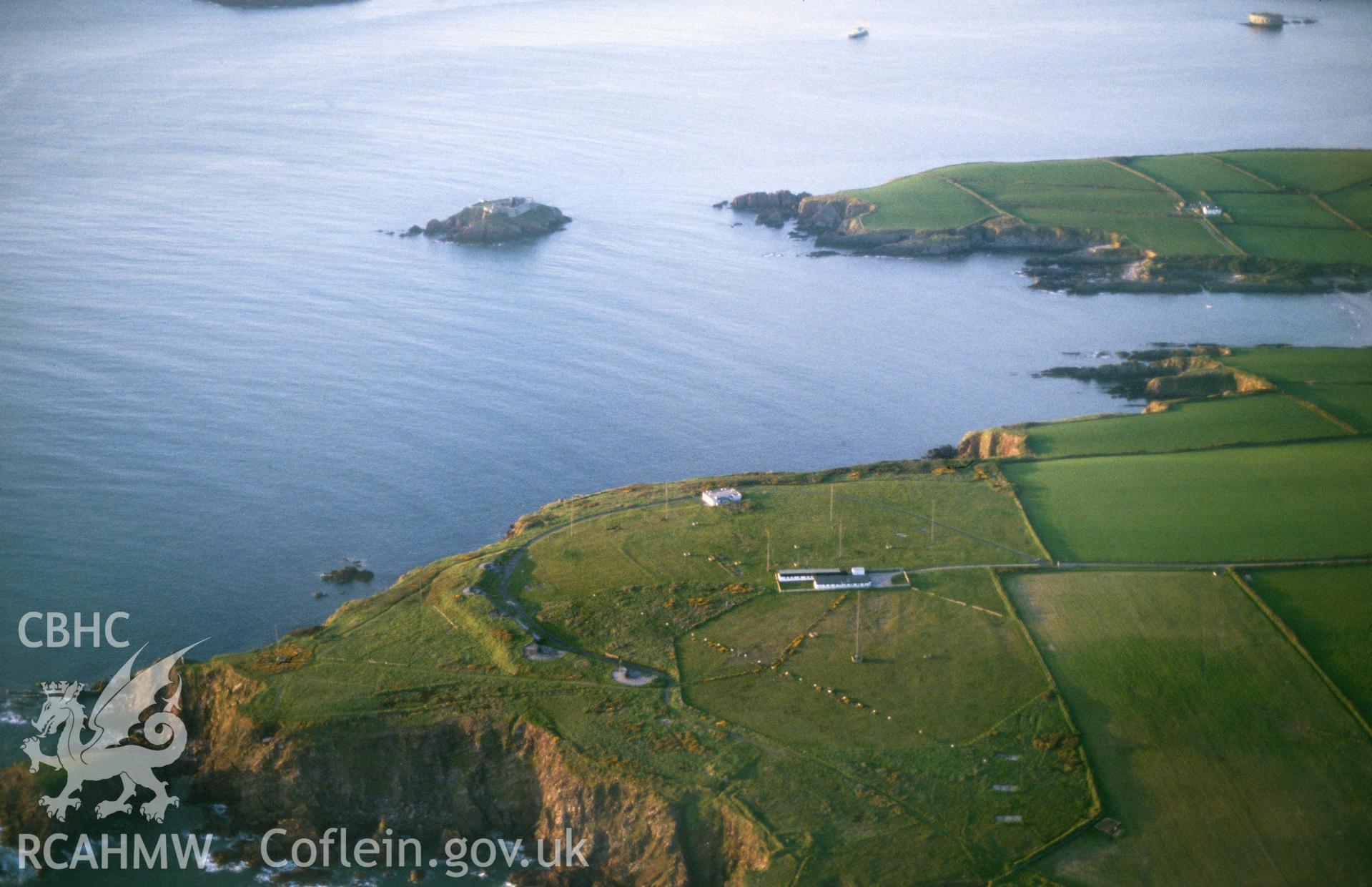 Slide of RCAHMW colour oblique aerial photograph of East Blockhouse, Angle, taken by C.R. Musson, 1989.