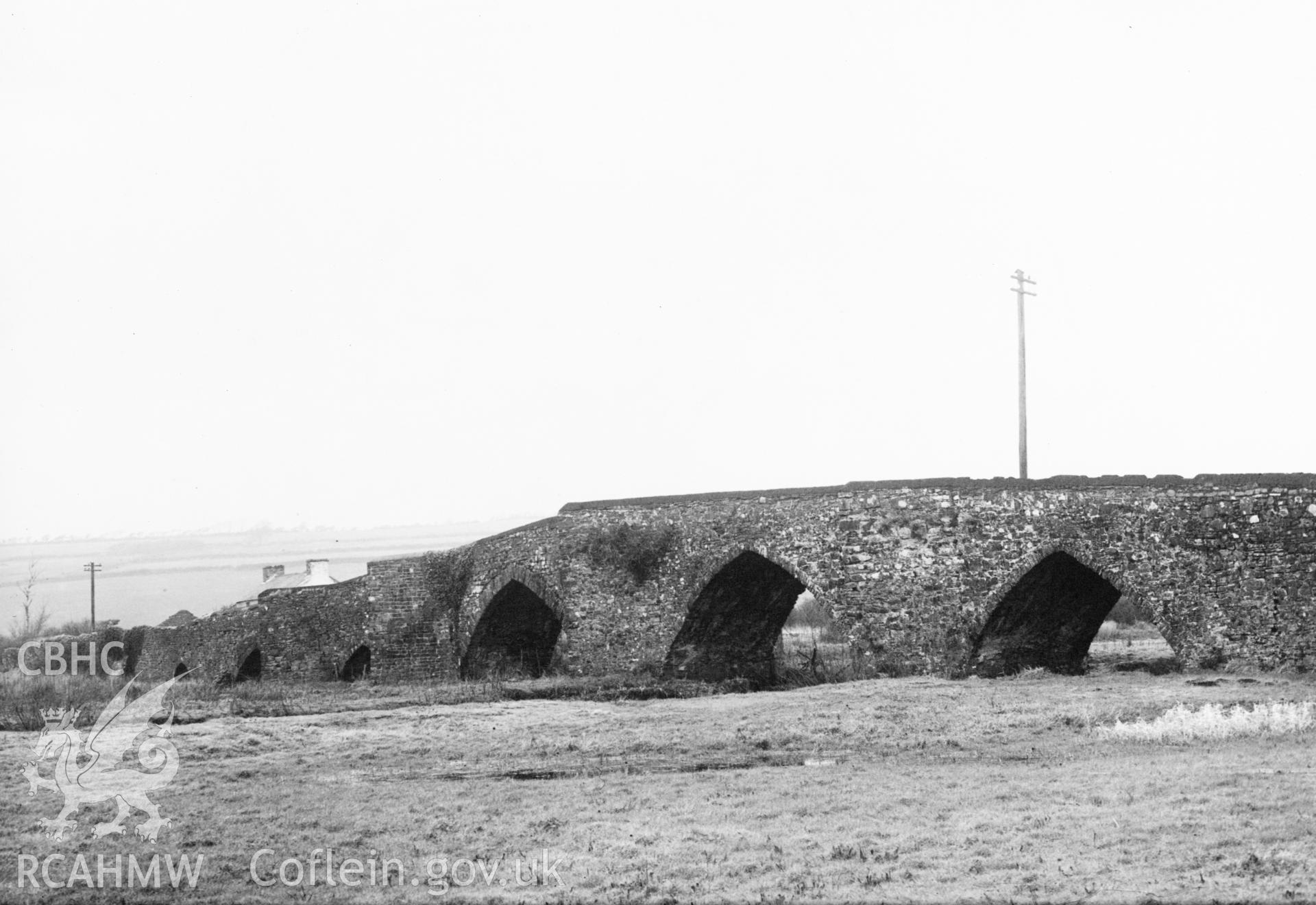 Mounted b&w photographic print showing view of Spwdder Bridge, Carmarthenshire, originally featured in a volume entitled "British Bridges" published by Public Works, Roads and Transport Congress, 1933.