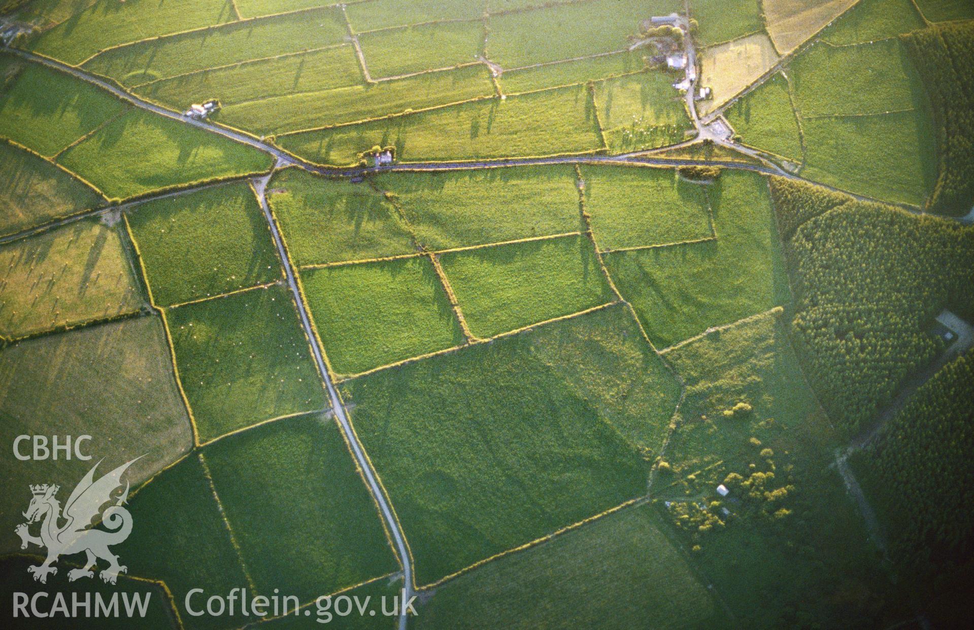 Slide of RCAHMW colour oblique aerial photograph of the enclosure at Tavern Farm, Henrys Moat, taken by C.R. Musson, 1990.