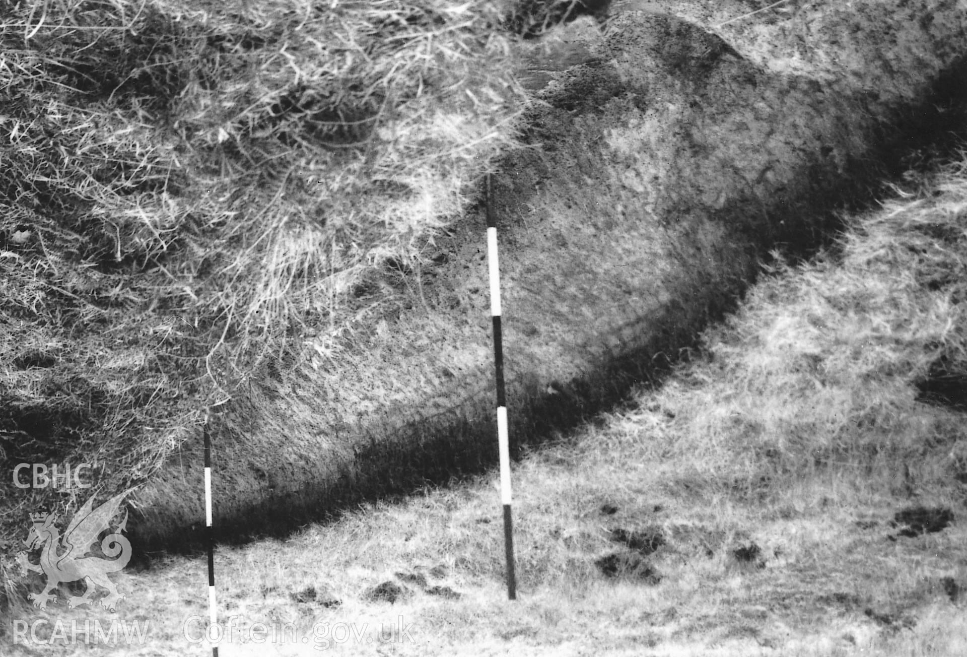 Digitised copy of black and white photograph of Gelligaer Common IV Roman practice camp showing a cross-section of the ditch made by a drainage cutting taken by J. K. St. Joseph in 1959, copied from RCAHMS St Joseph Collection for University of Wales Press publication "Roman Camps in Wales and the Marches ", by J.L. Davies and R.H. Jones, Board of Celtic Studies, University of Wales.