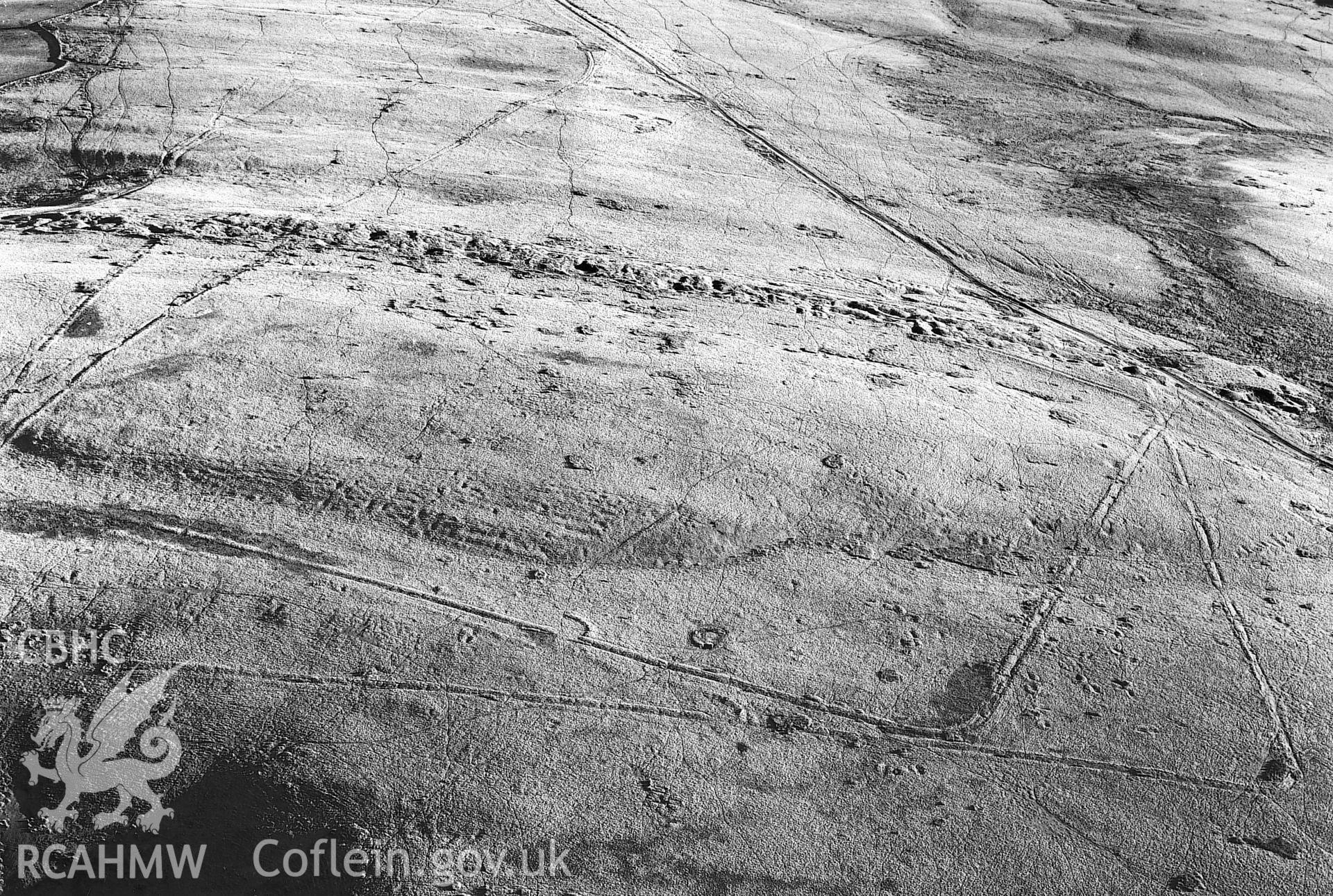 RCAHMW Black and white oblique aerial photograph of Y Pigwn Marching Camps, Myddfai, taken by CR Musson, 1988.