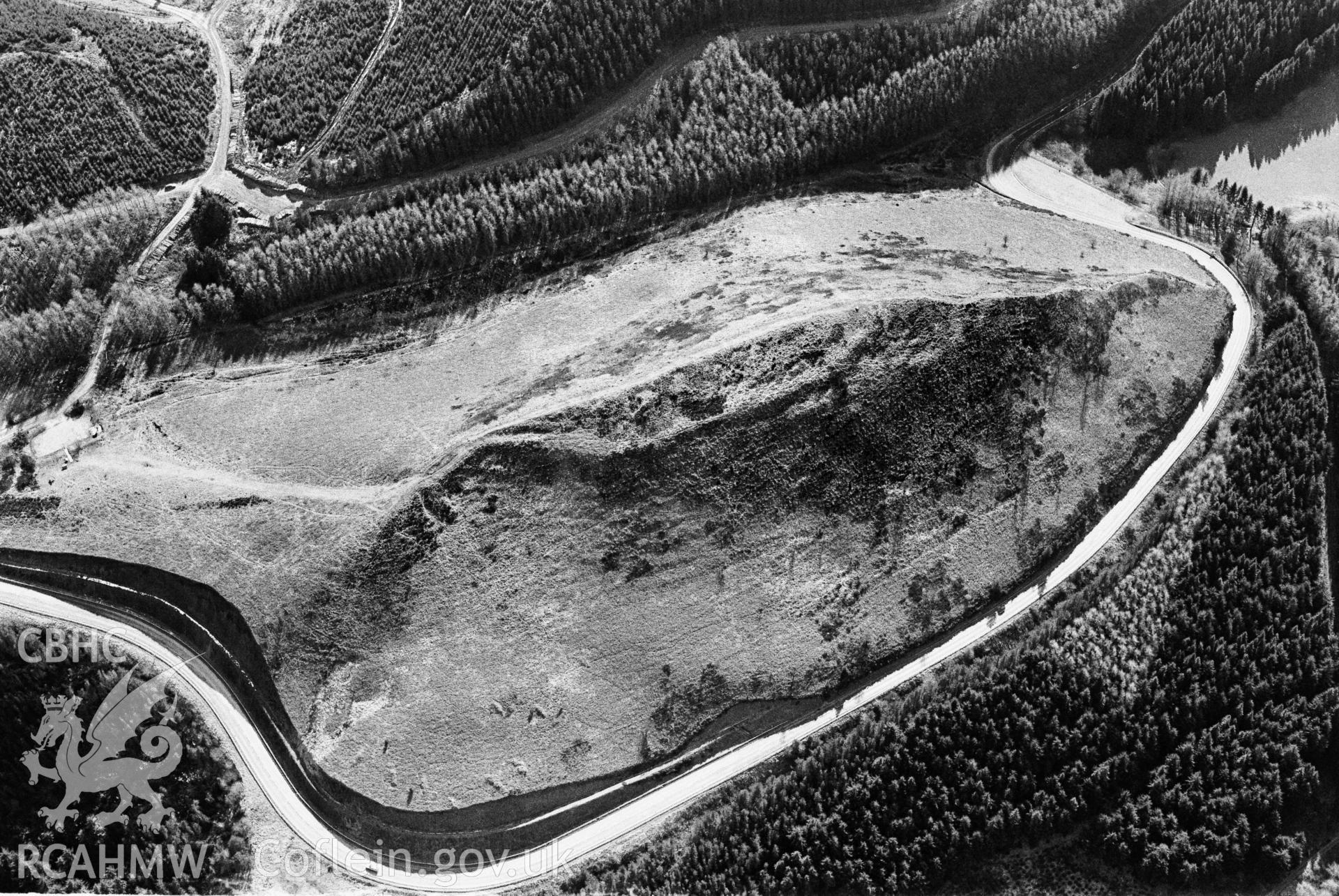 RCAHMW Black and white oblique aerial photograph of Sugarloaf Hillfort, Llanfair-y-Bryn, by Toby Driver, 2001.