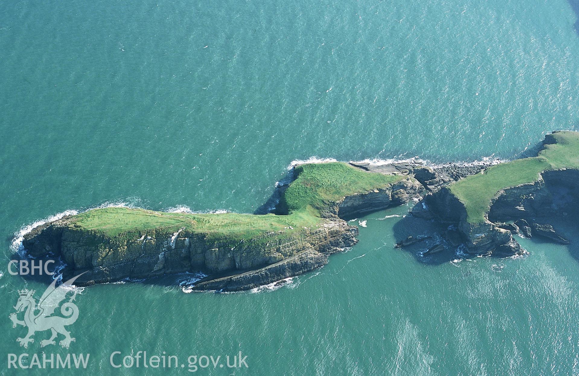 RCAHMW colour slide oblique aerial photograph of Ynys-lochtyn Cave, Llangrannog, taken on 19/10/1999 by Toby Driver