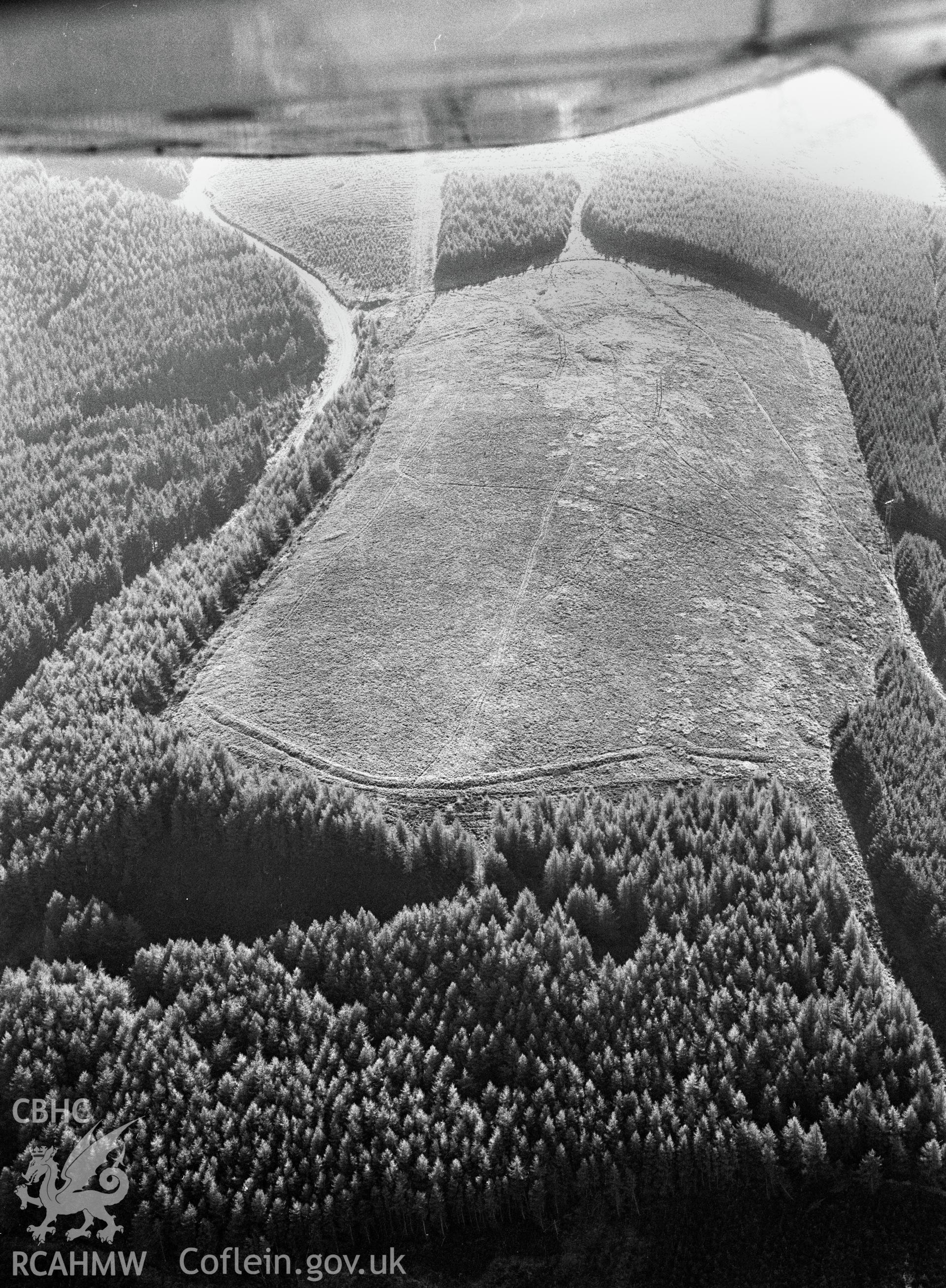 RCAHMW Black and white oblique aerial photograph of Twyn-y-bridallt, Roman Camp, Ferndale, taken by Toby Driver