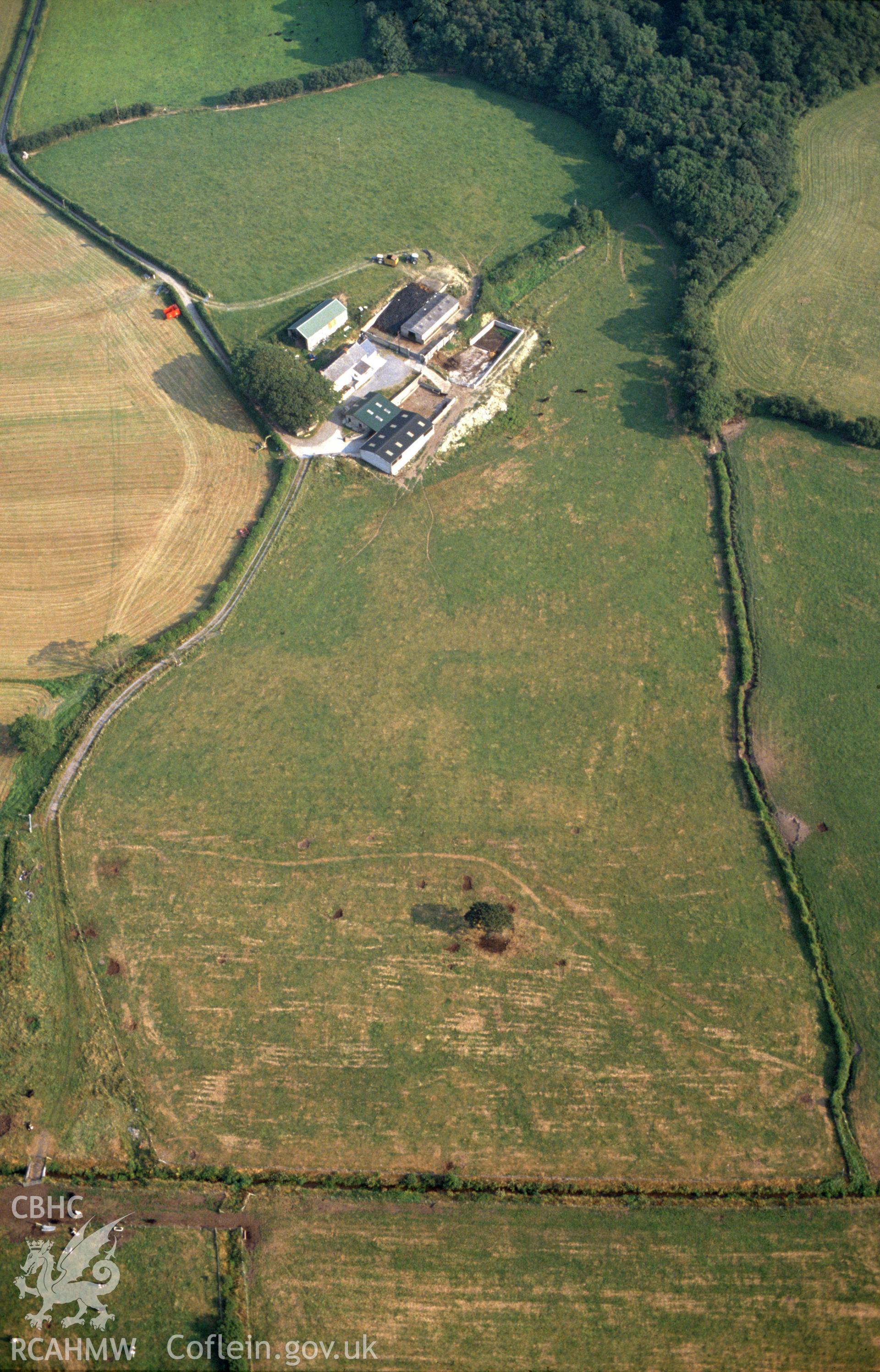 Slide of RCAHMW colour oblique aerial photograph of Ynyscapel enclosure, Ceulanmaesmawr, taken by C.R. Musson, 1990.