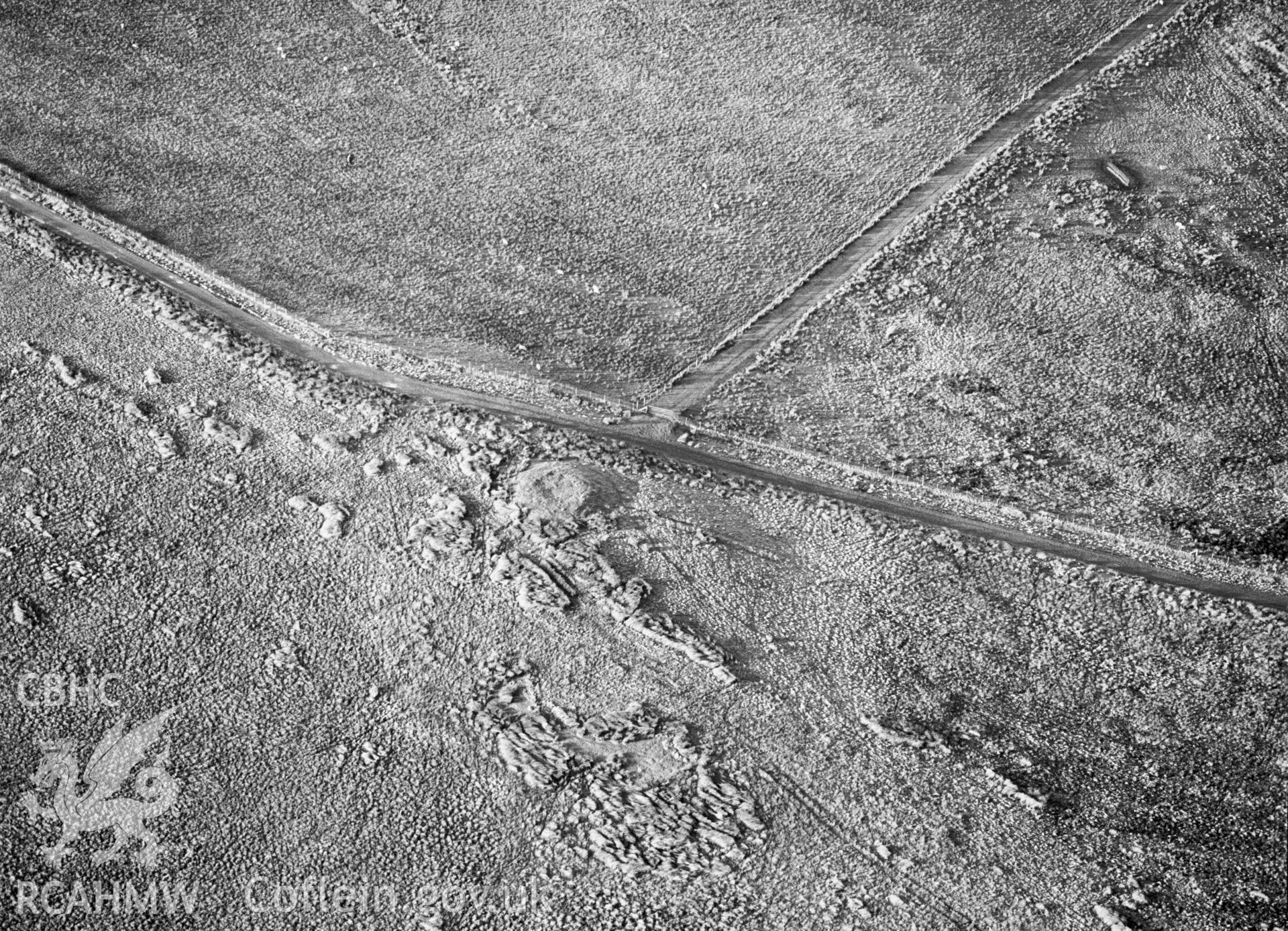 RCAHMW Black and white oblique aerial photograph of Pen-y-groes Isaf Cairn, Aberhafesp, taken by C.R. Musson, 07/01/94