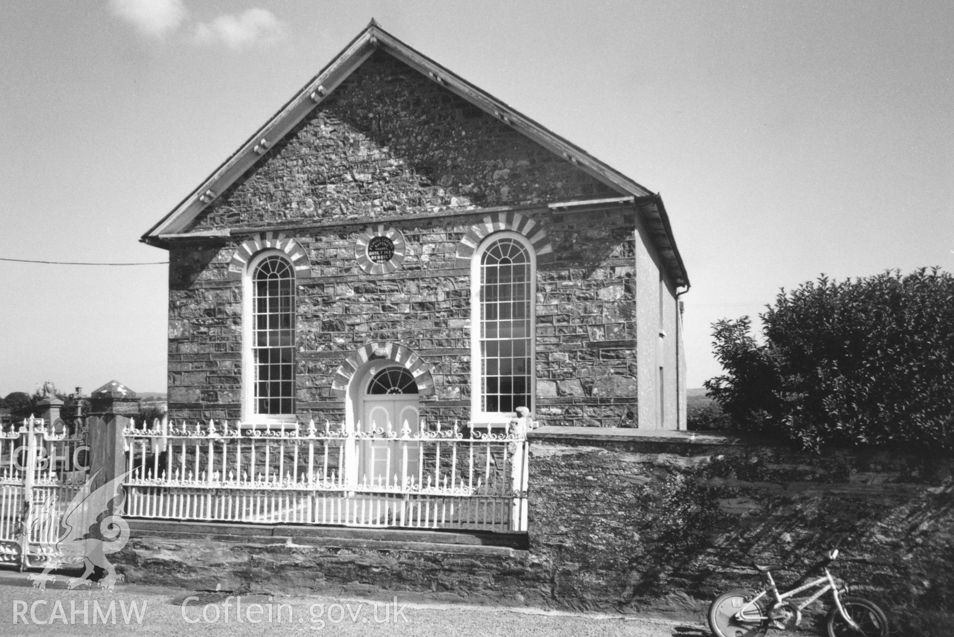 Digital copy of a black and white photograph showing an exterior view of Penuel Welsh Baptist Chapel, Cemaes, taken by Robert Scourfield, c.1996.