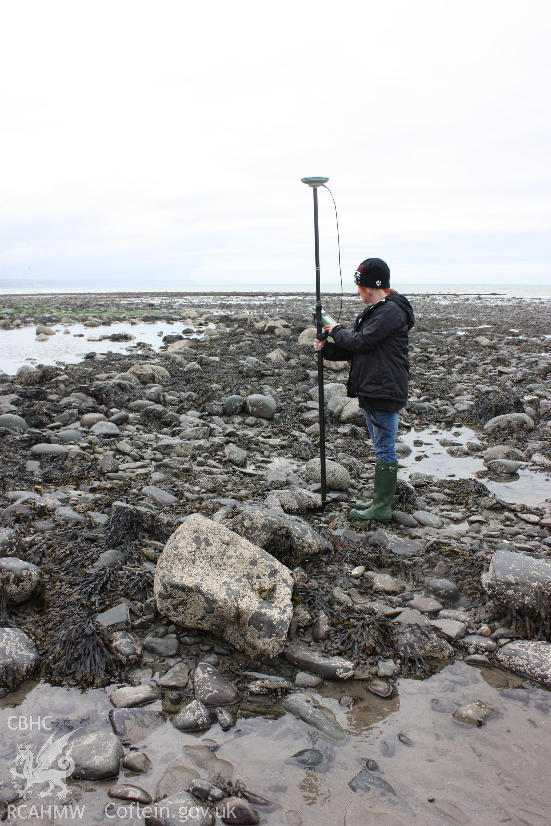 Northern end of fish trap arm (centre), looking south. Shows pool of water still retained by arm of fish trap (centre left). RCAHMW staff member adjacent to dry stone wall and for scale.