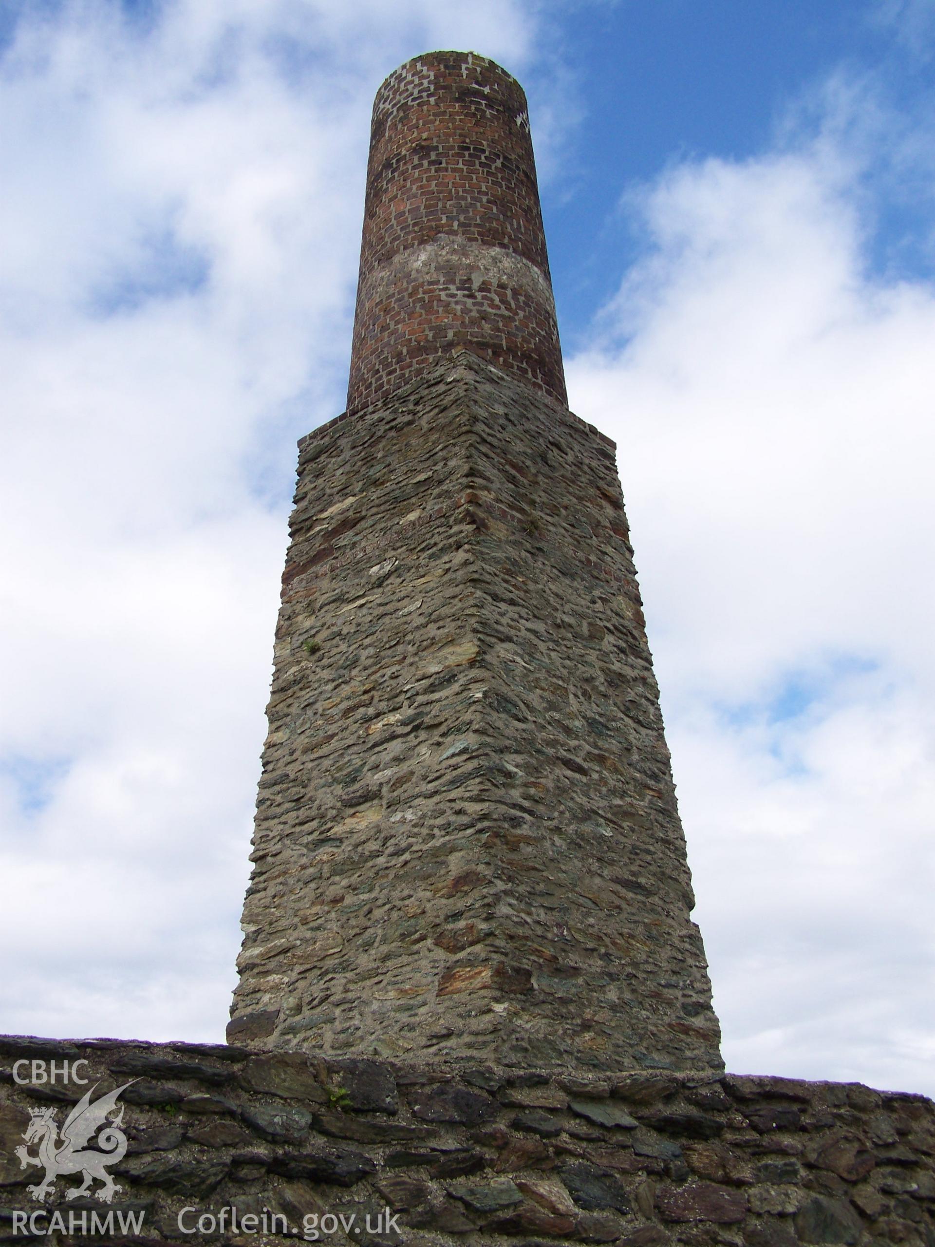 View the chimney from the south (outside of wall) showing the change in the profiel (square and round) and change in materials (stone to brick).