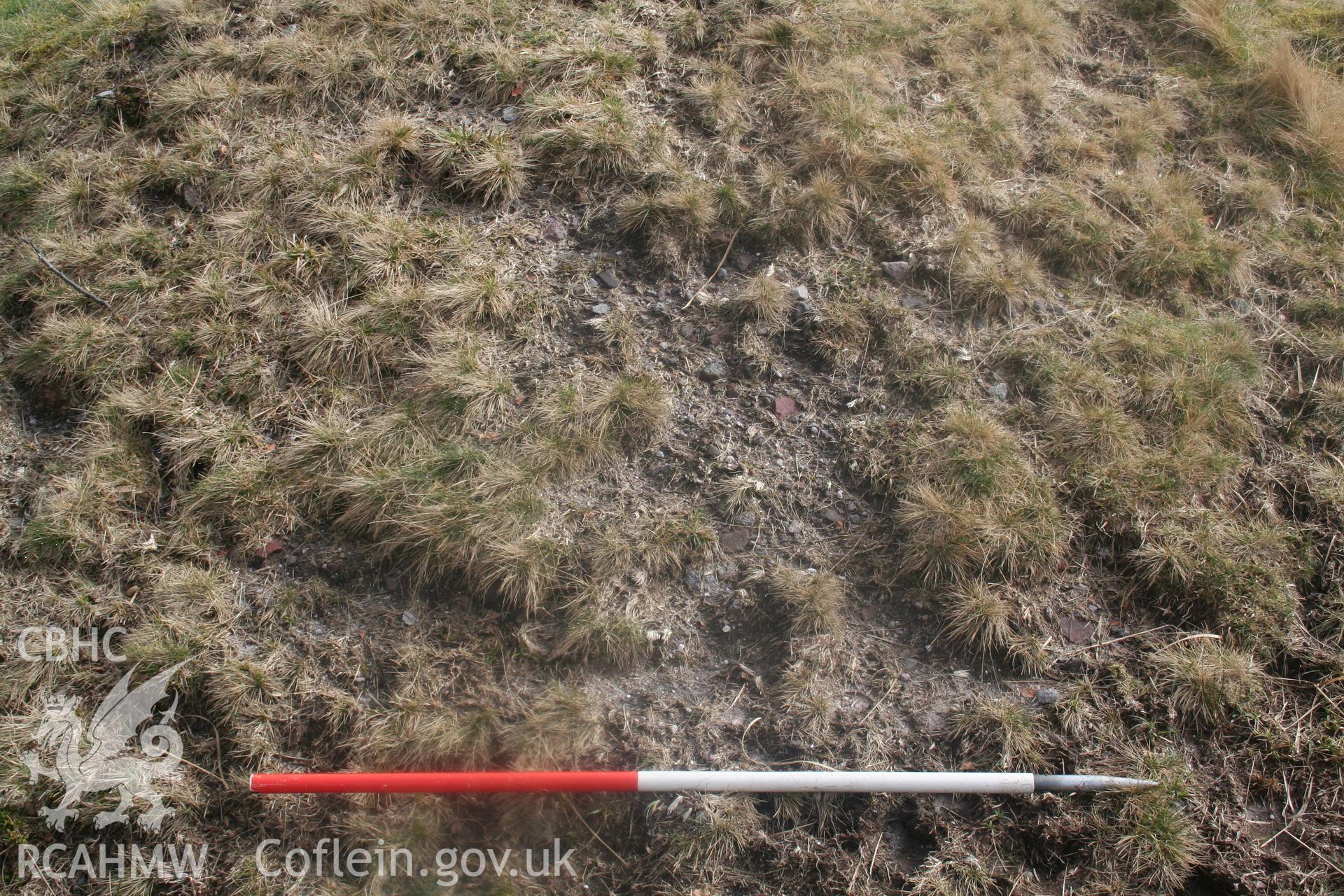 View of small-grade stone make up of the mound on its eroded west side; 1m scale.