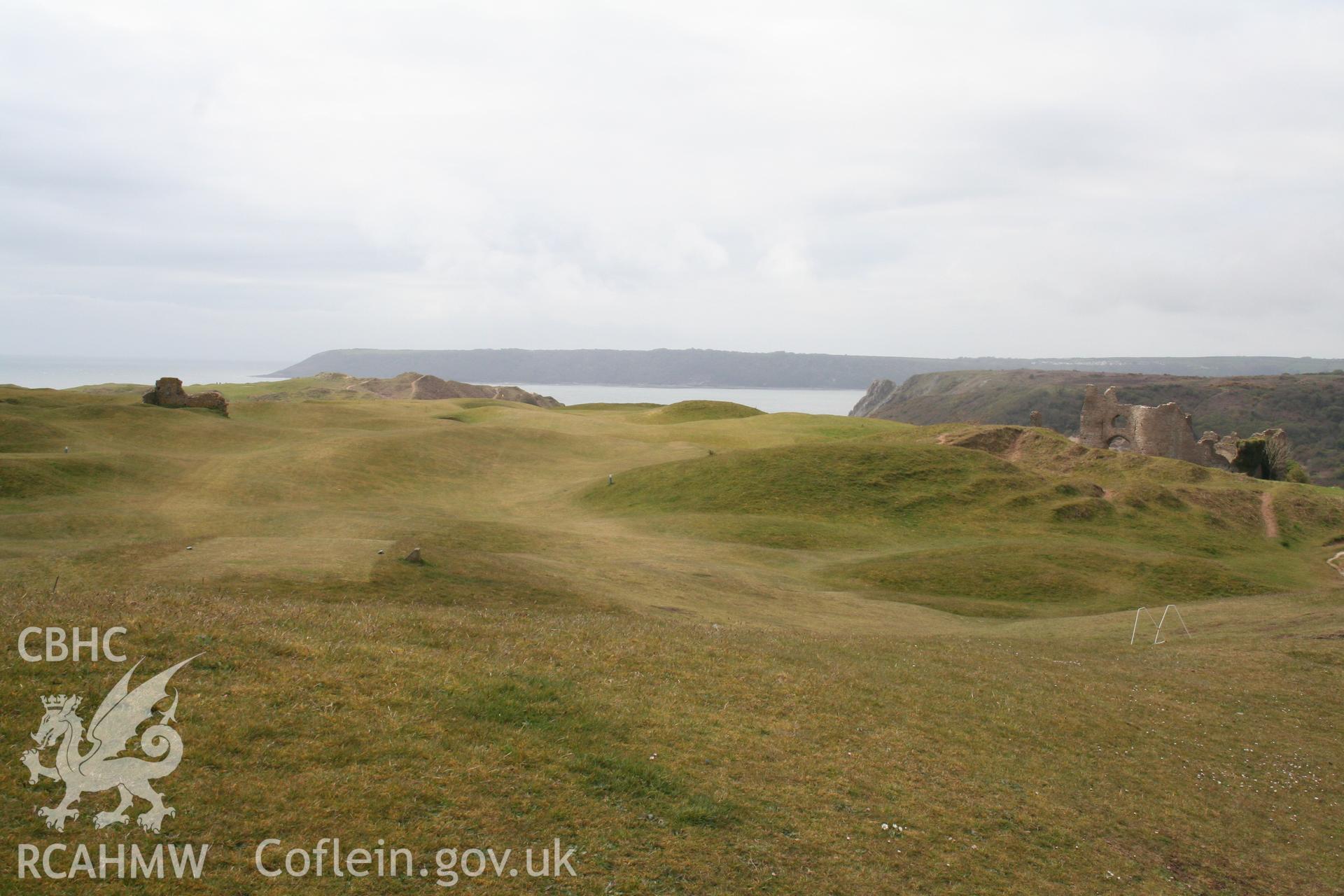 View of church (left) and castle (right) across the site of the besanded village of old Pennard, from the north-east.