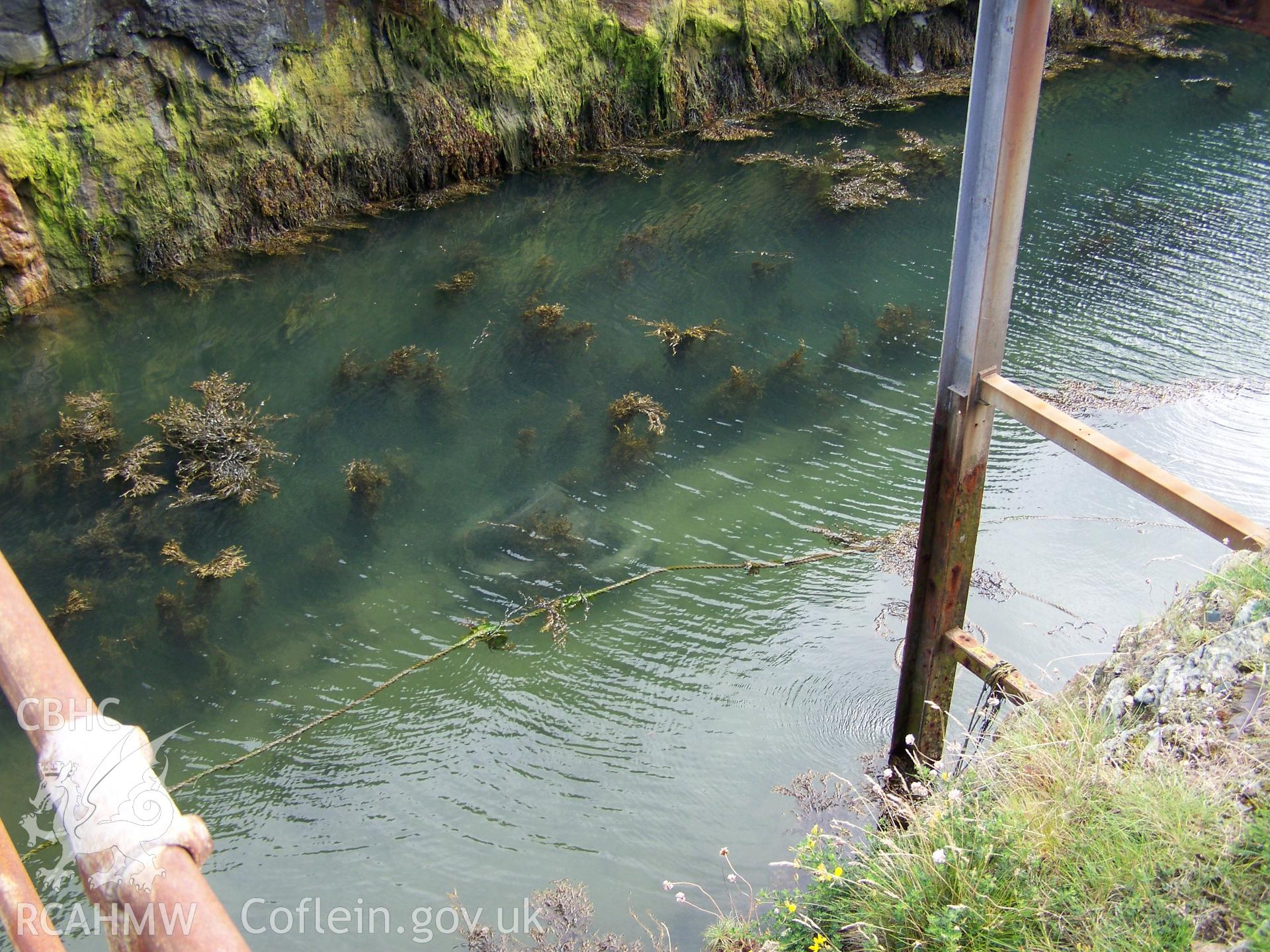 The concrete launch way just visible underwater at the bottom of the dry dock.