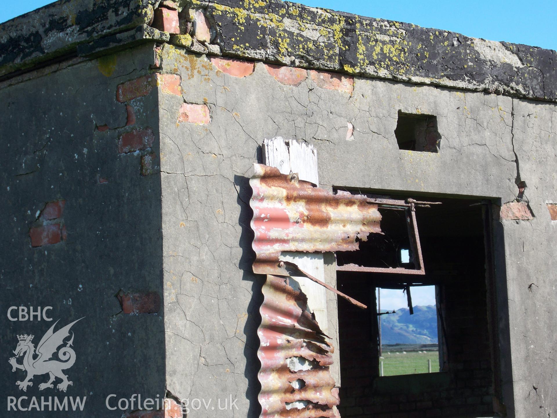 Detail of southwest corner of building showing brick construction, concrete slab roof and metal window framing