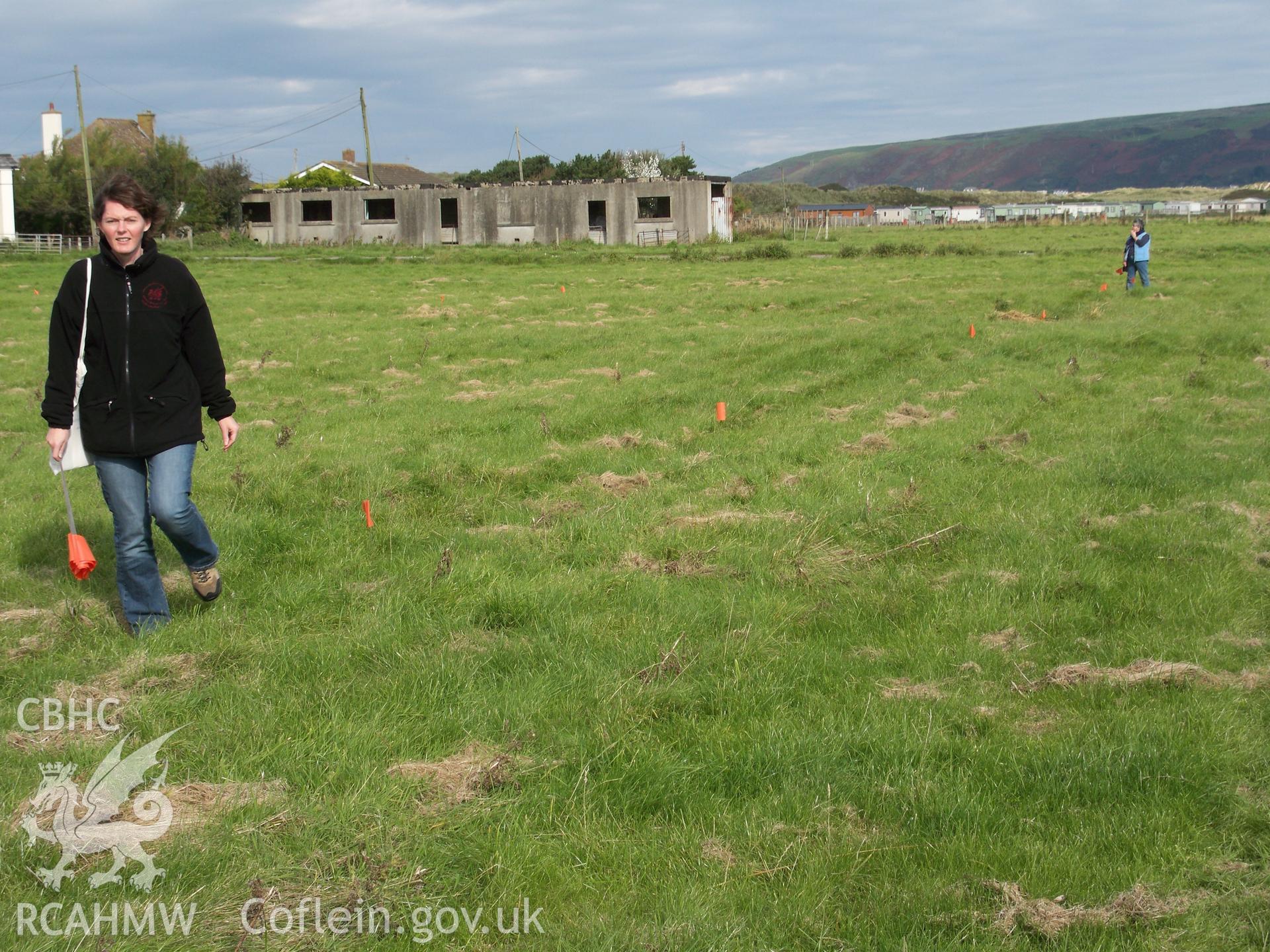 Alignment of axis of 12-hut complex being determined by RC staff and marked with survey flags.