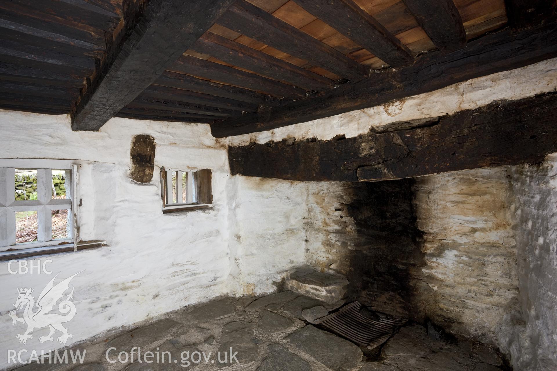 Interior, window, fireplace and remains of cruck in wall.